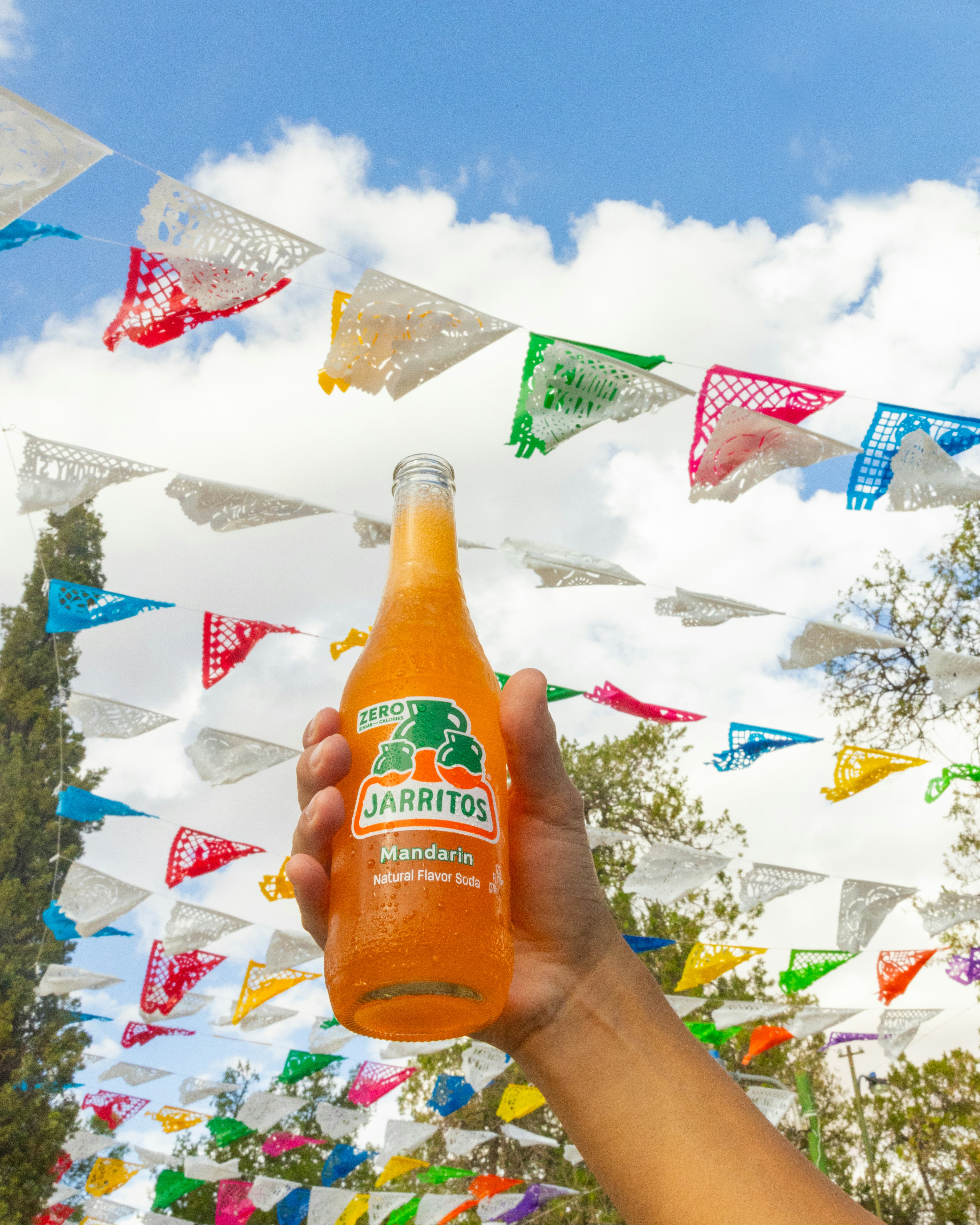 A person holding a bottle of orange juice