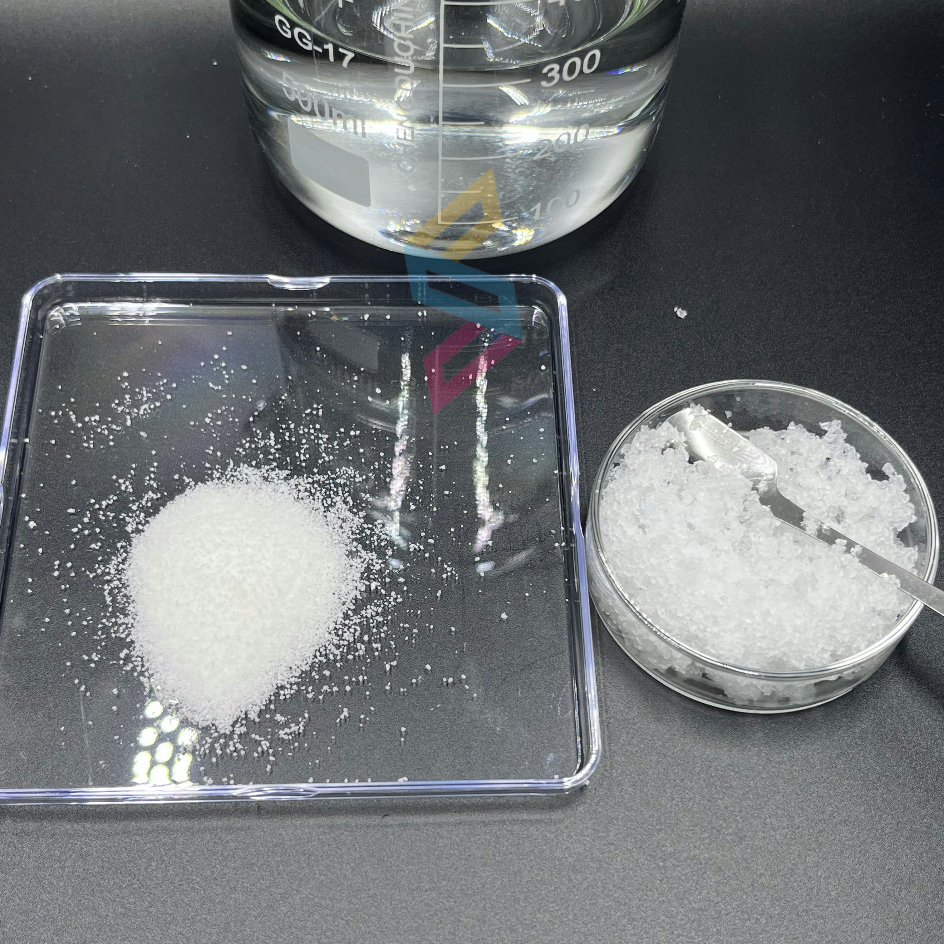 White crystalline amino acid powder in laboratory glass dish, bright clinical lighting