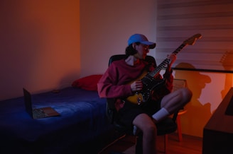 A man sitting in a chair playing a guitar