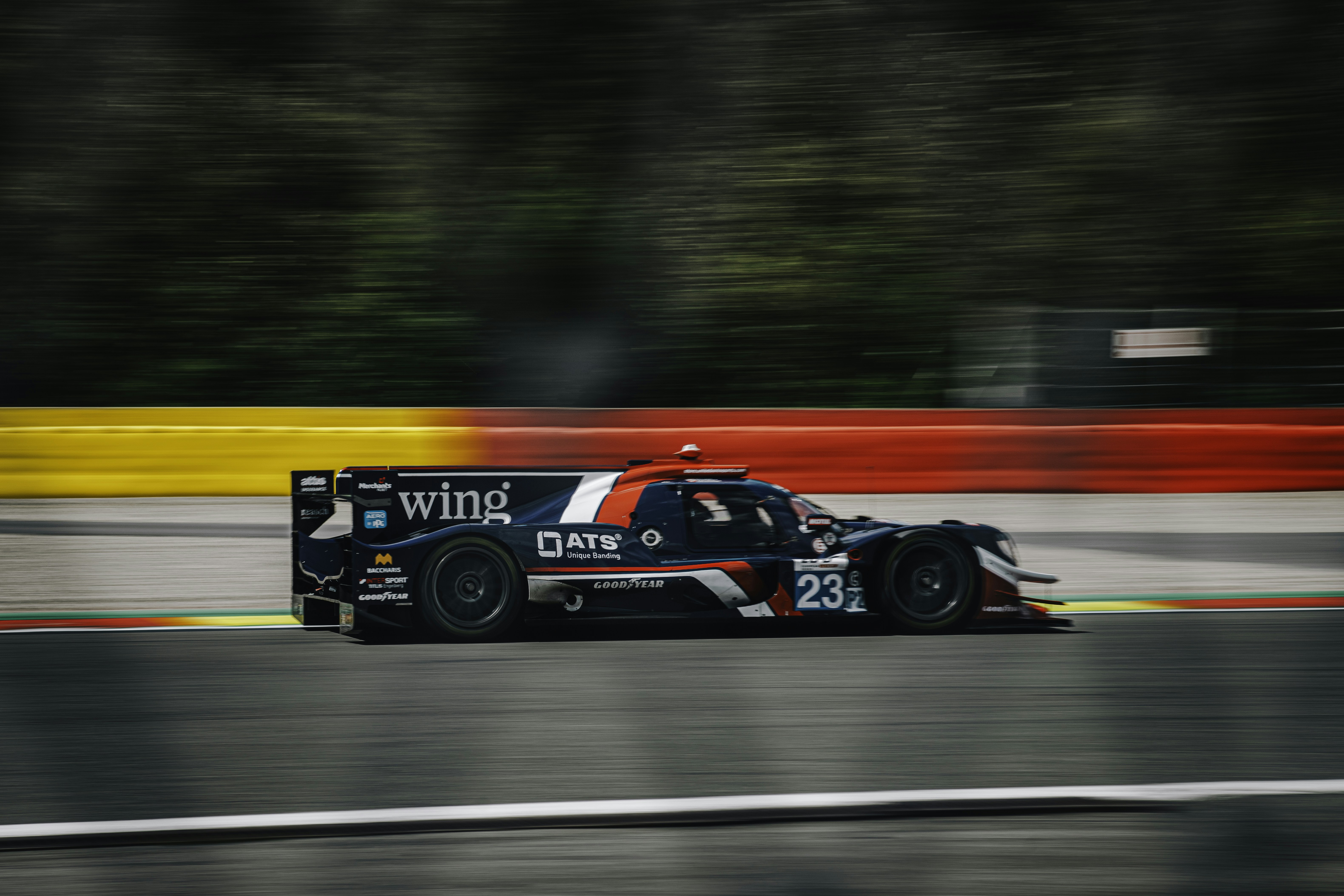 A racing car driving on a race track photo – Free Car Image on Unsplash