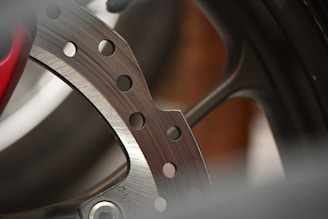 A close up of a motorcycle wheel with a red brake disc