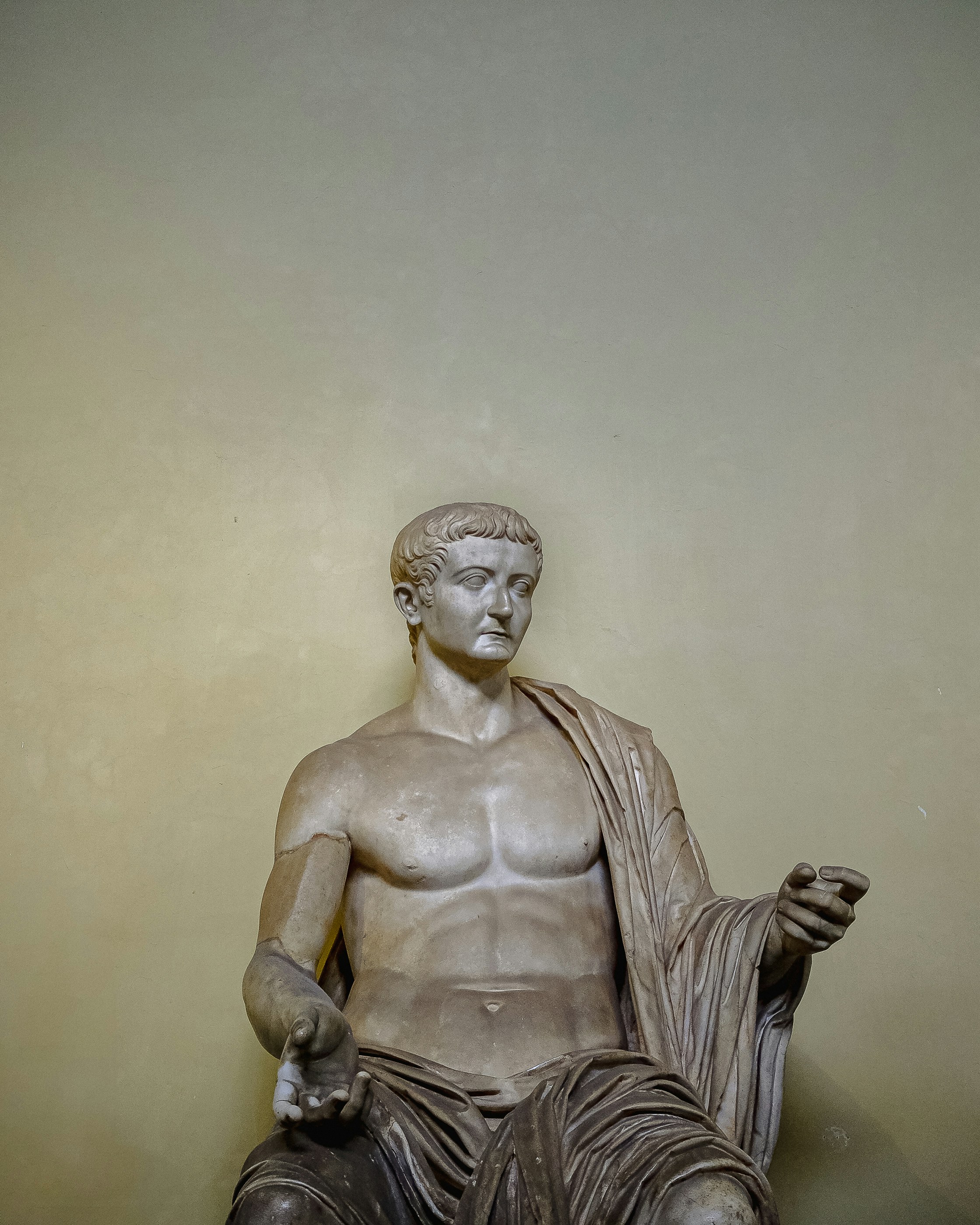 Una statua di un uomo seduto sopra un tavolo