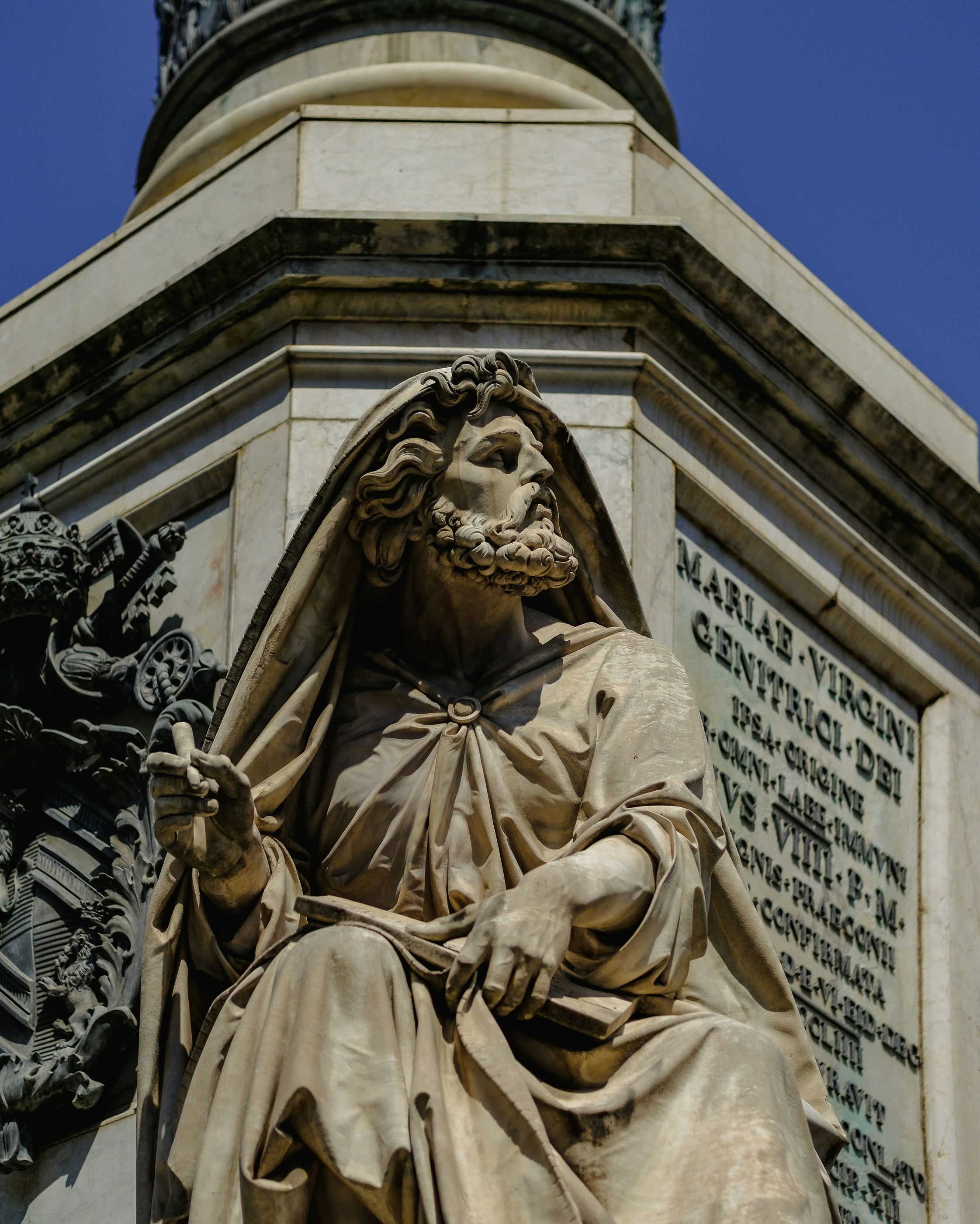 Una statua di un uomo seduto in cima a un edificio