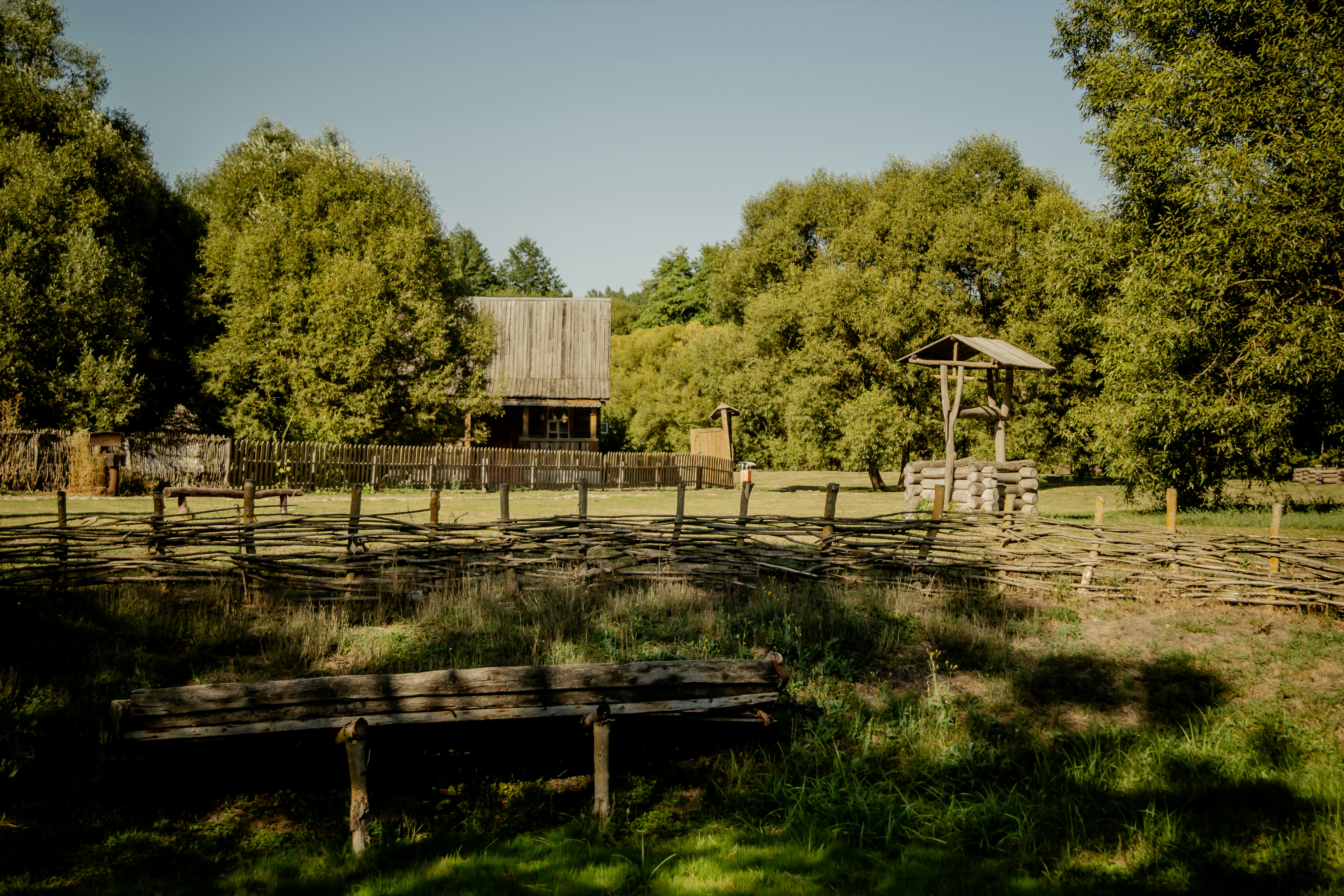 A wooden bench sitting in the middle of a field