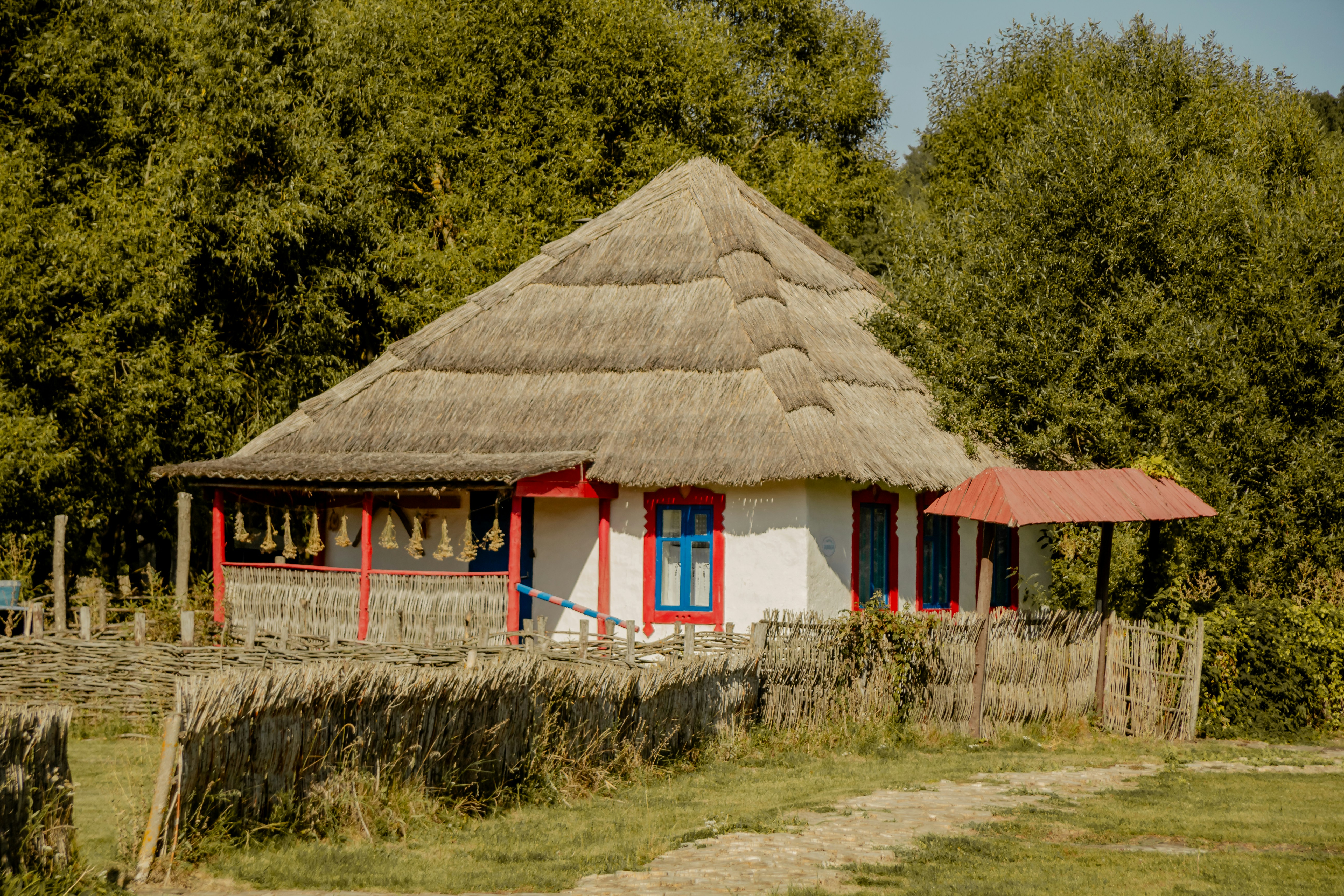A small hut with a thatched roof in a field