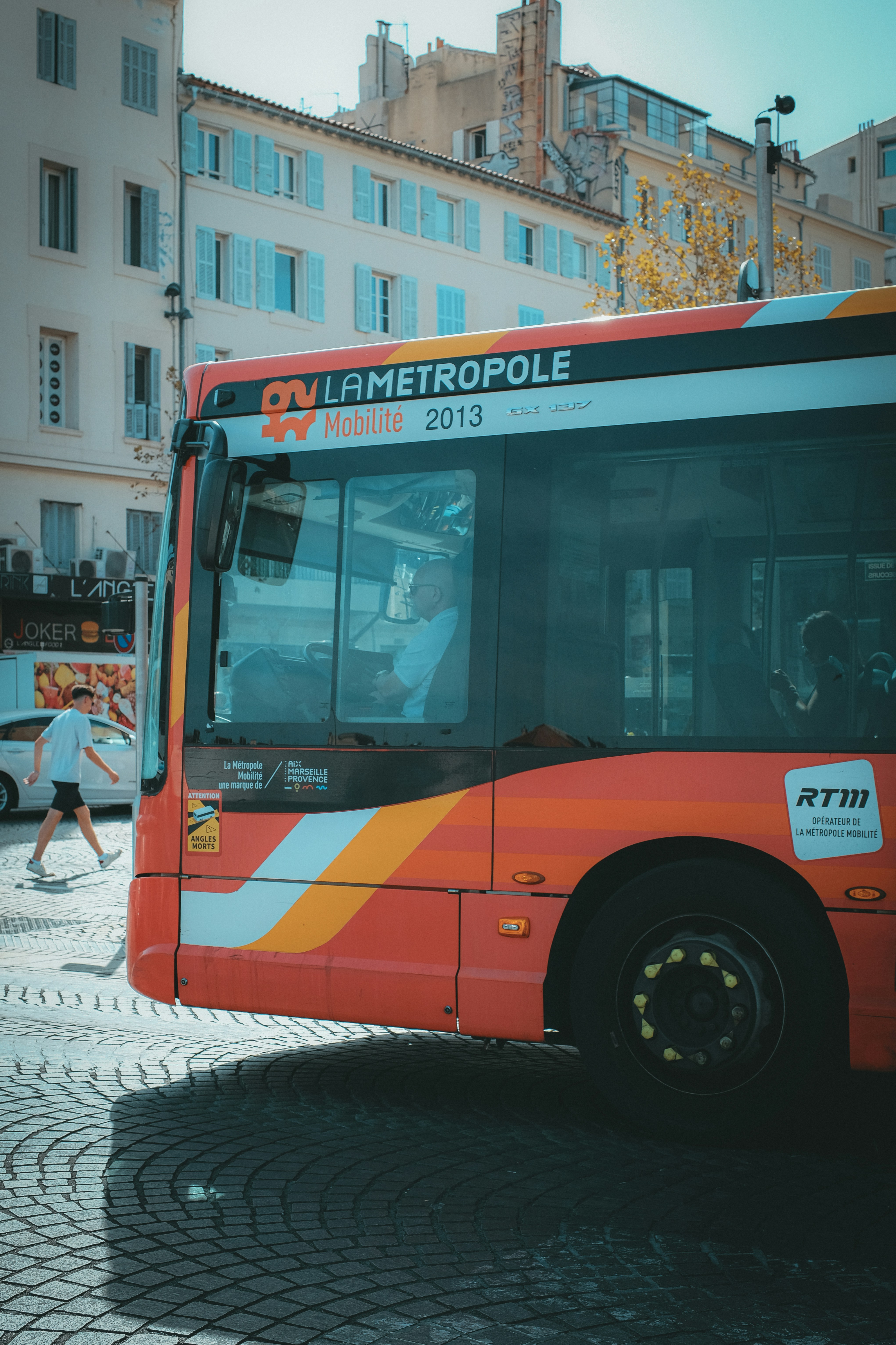 Ein roter Bus parkt auf einer Kopfsteinpflasterstraße