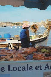 A man sitting on a boat selling food