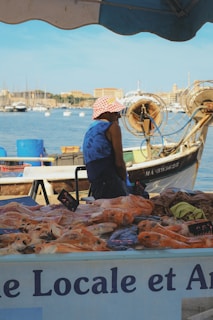 A man sitting on a boat selling food