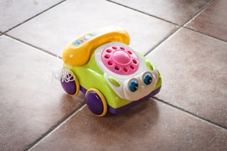 A toy car sitting on a tile floor