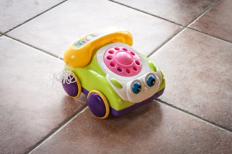 A toy car sitting on a tile floor