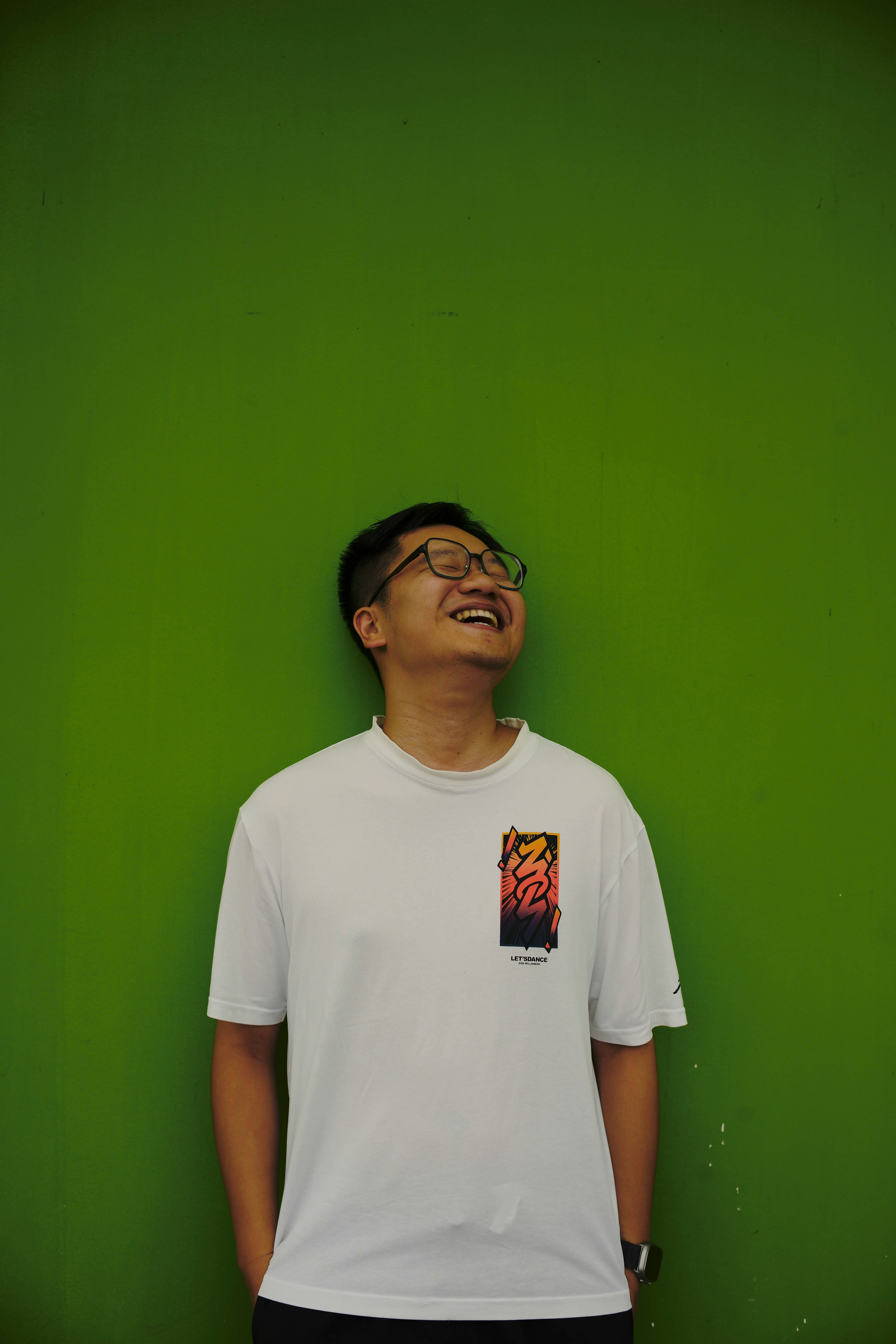 A man standing in front of a green wall