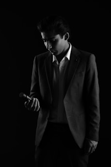 A man in a suit looking at his cell phone