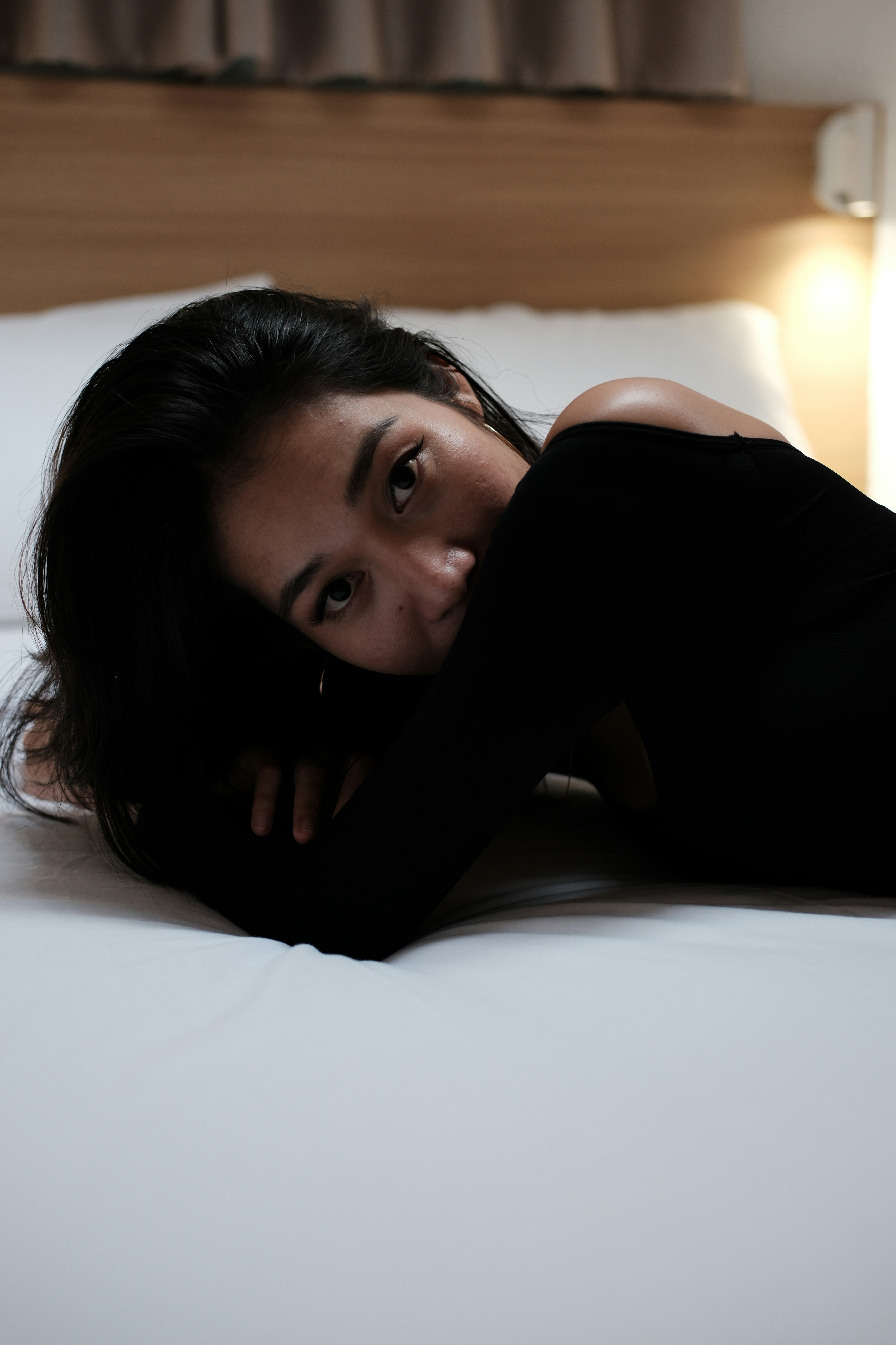 A woman laying on top of a white bed