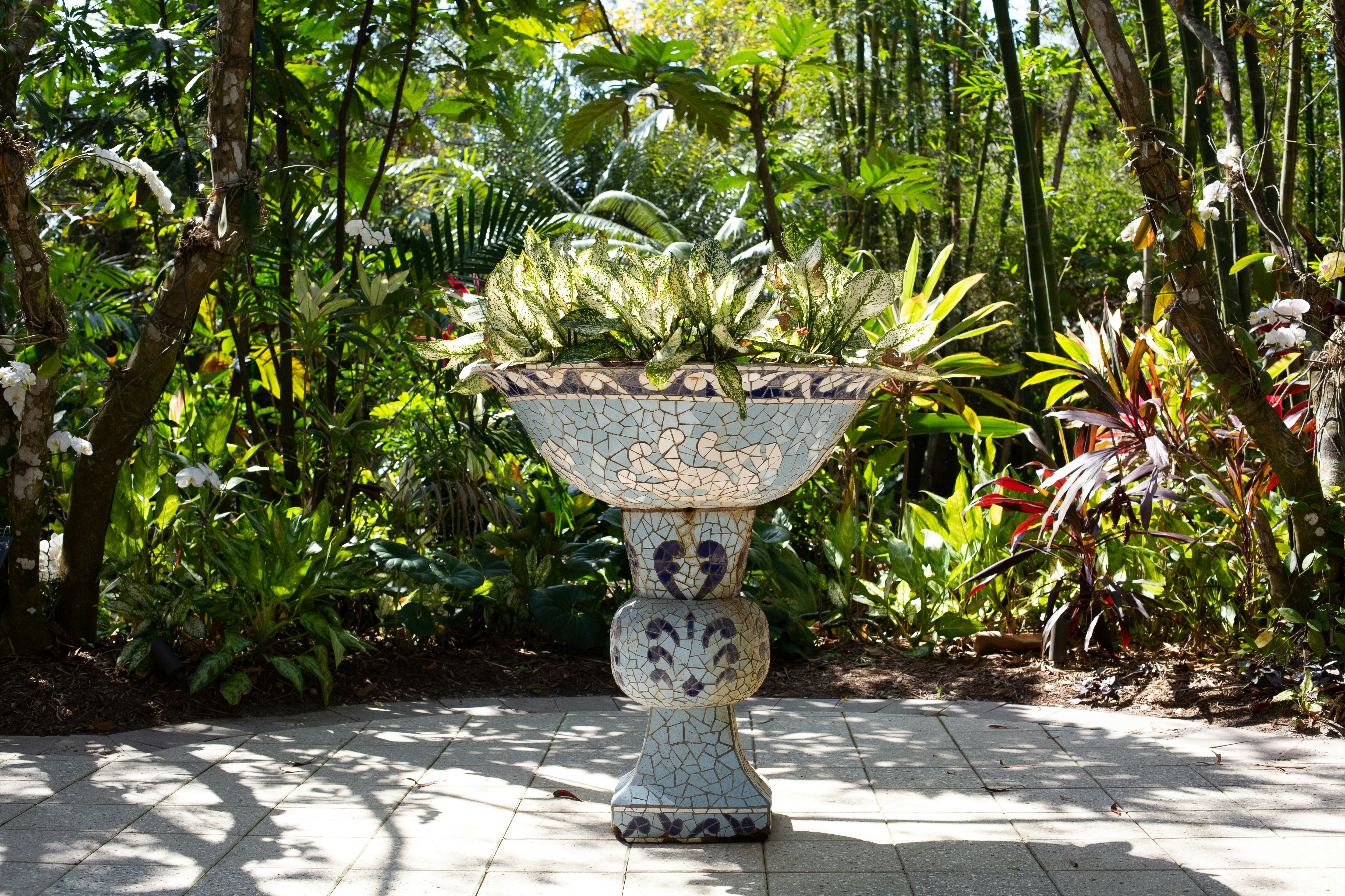 A white vase sitting on top of a sidewalk