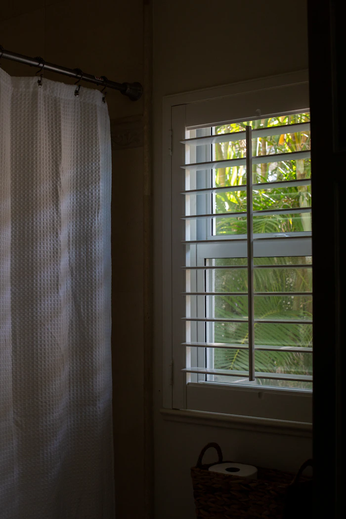 Bathroom window fitted with louvred shutters