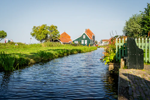 Canal bordé de maisons de bois vert et de barrières