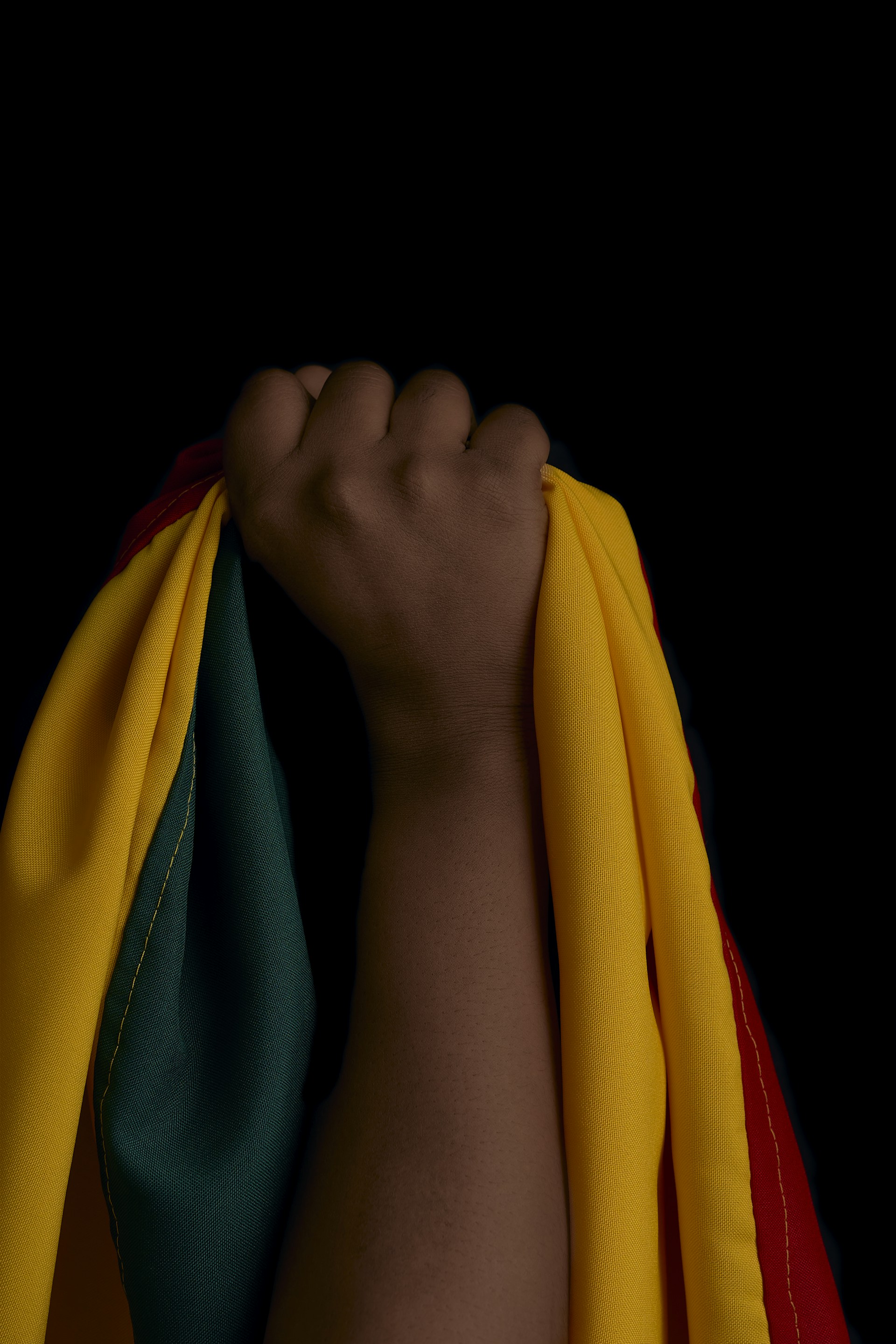 A person's arm wrapped in a yellow and green scarf