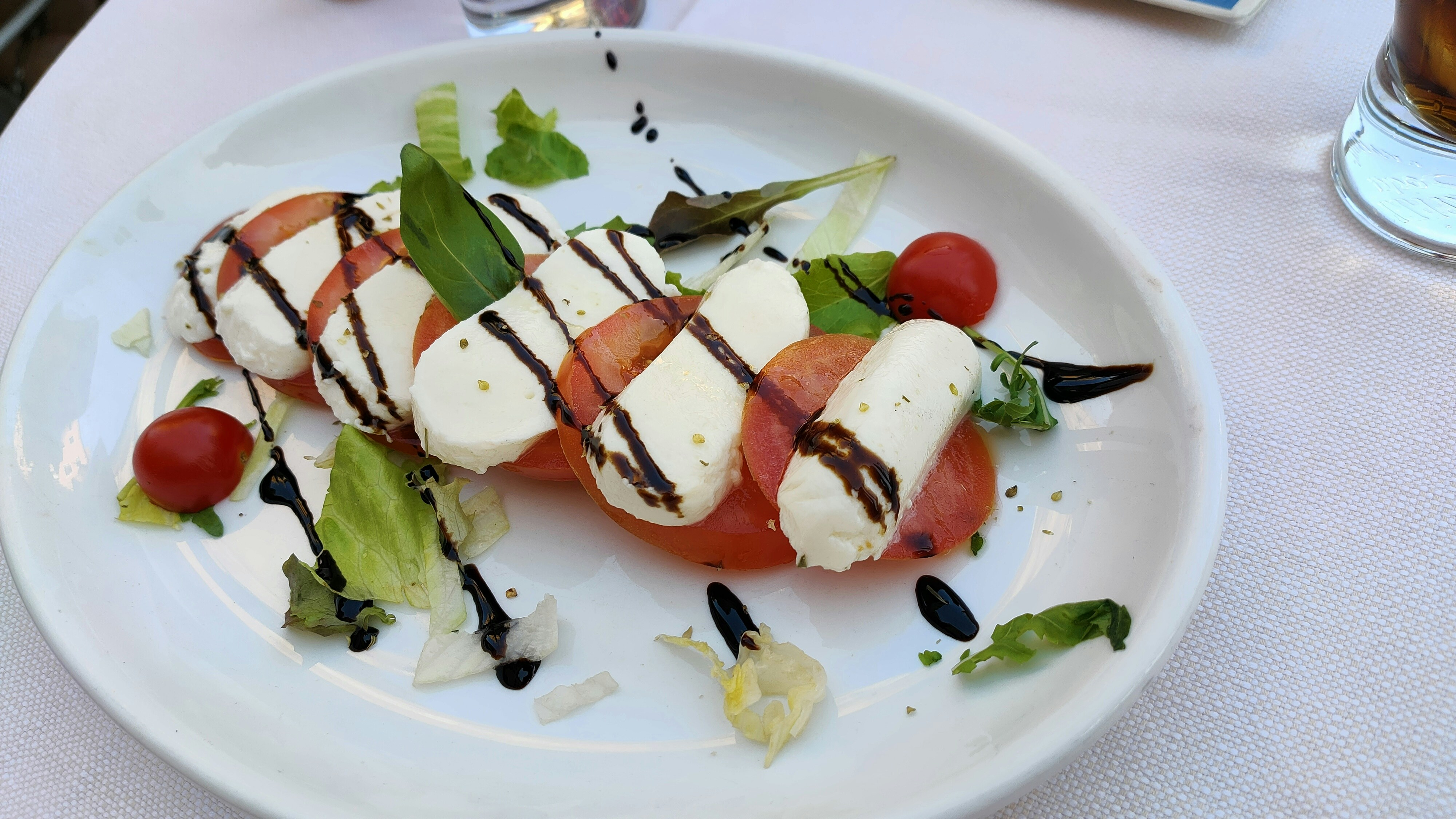 Fresh caprese salad with buffalo mozzarella sliced tomatoes and basil drizzled with olive oil