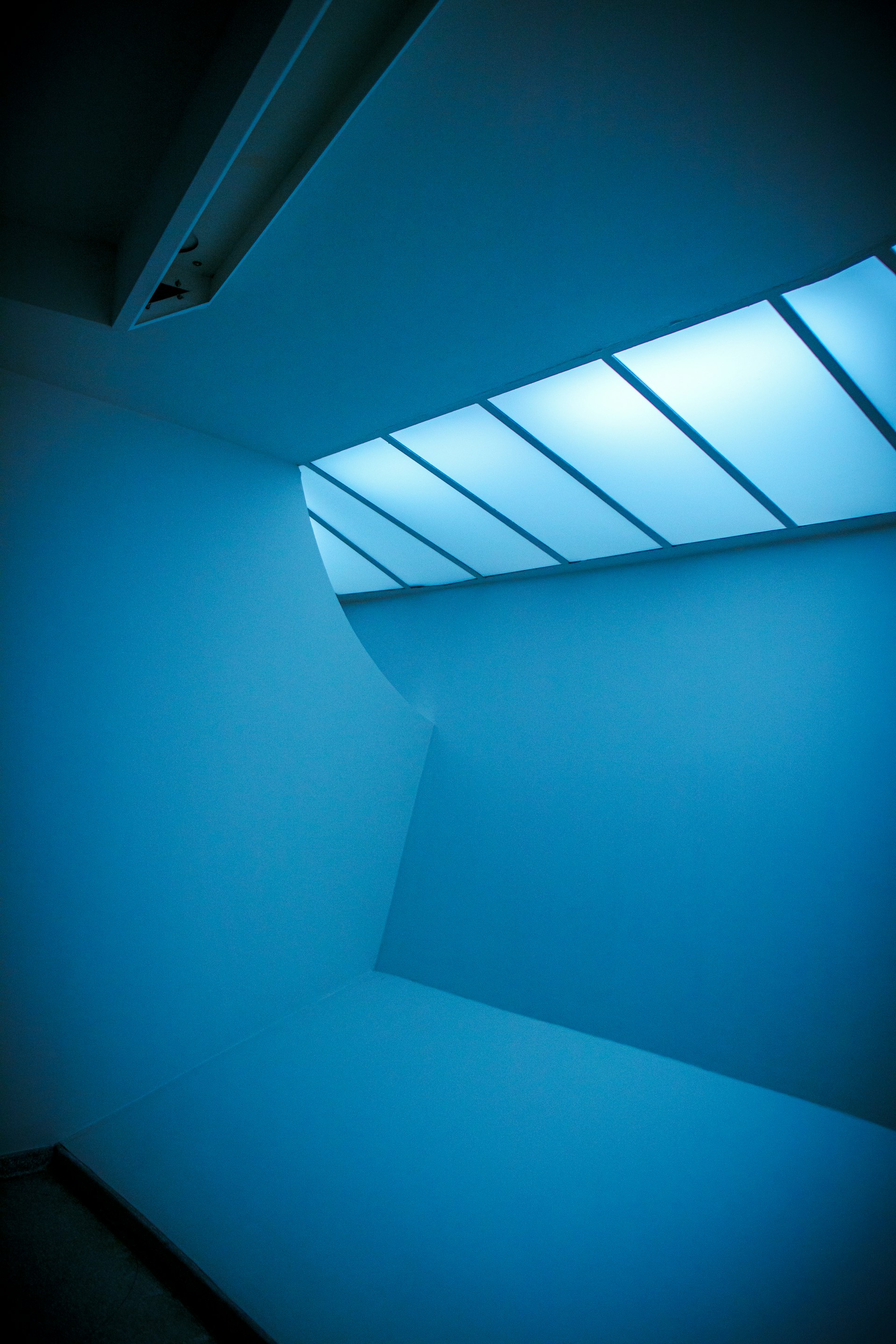 An empty room with a blue light coming from the ceiling