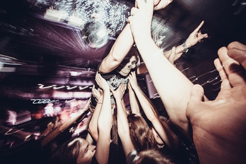 A group of people holding their hands up in the air