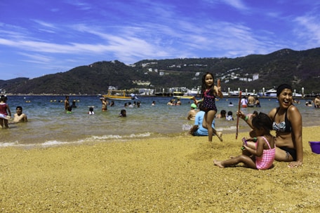 A group of people sitting on top of a sandy beach