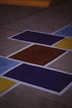 A skateboard is sitting on the ground painted with squares