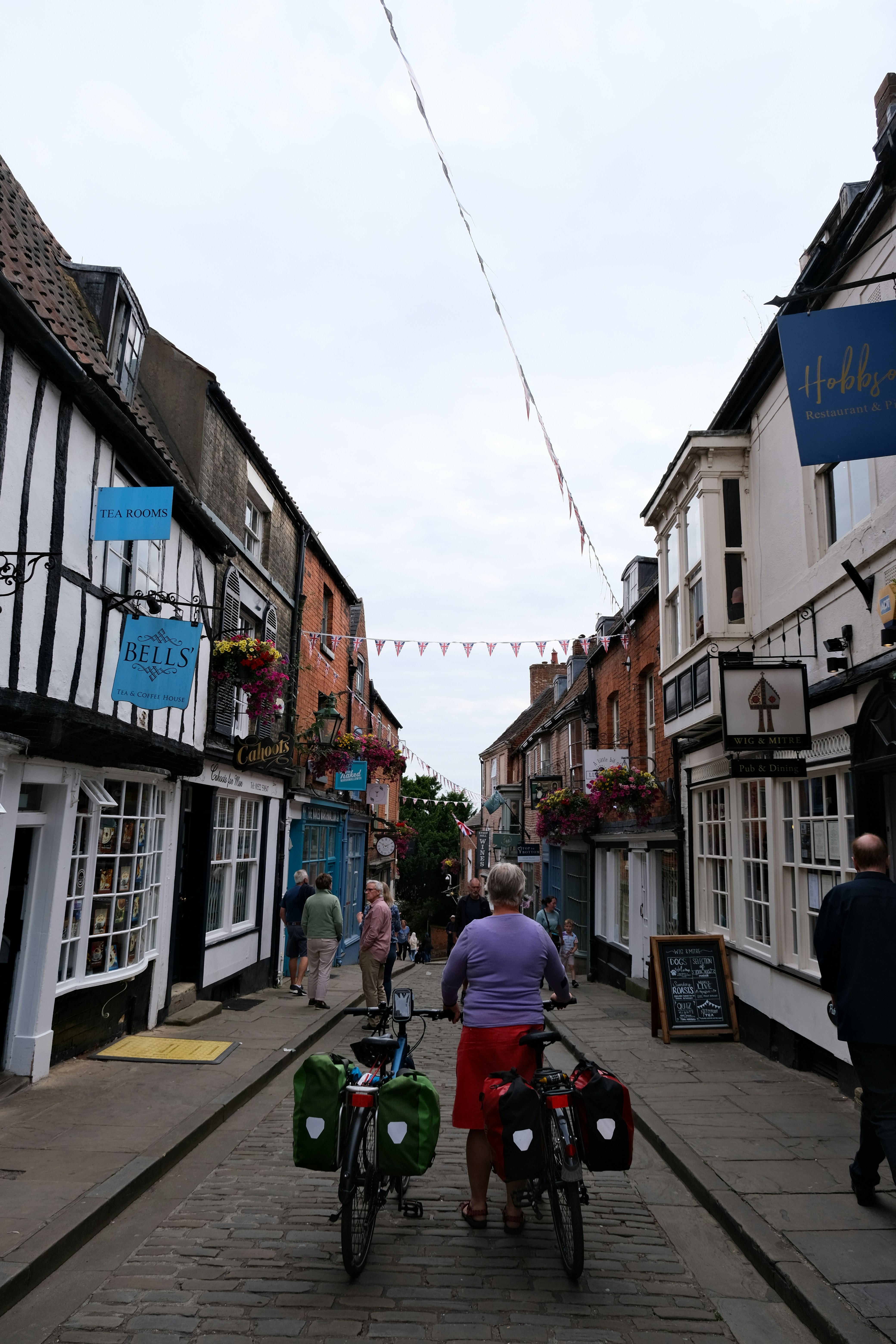 A man riding a bike down a street next to tall buildings