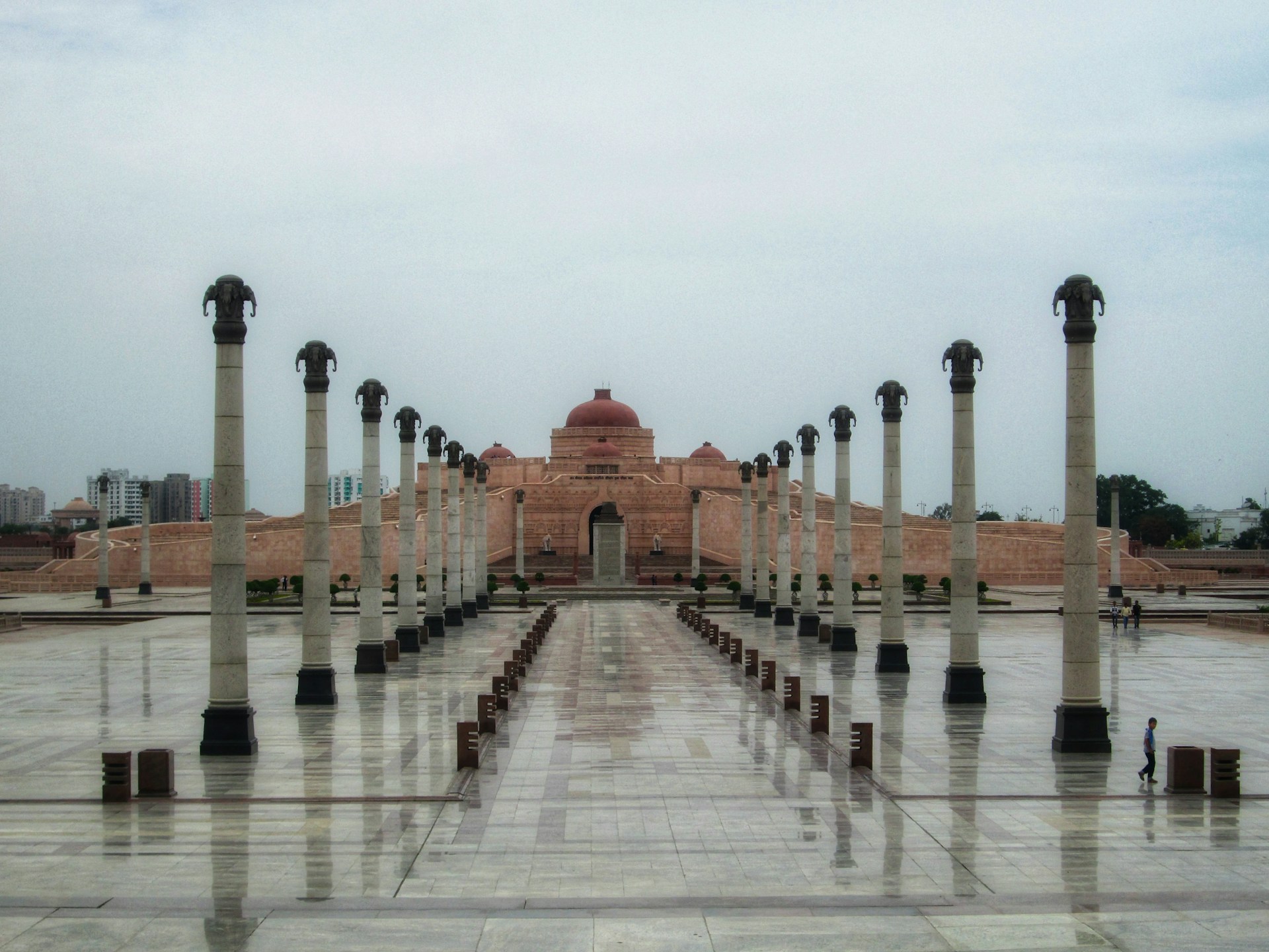 A large building with columns and a clock tower in the background
