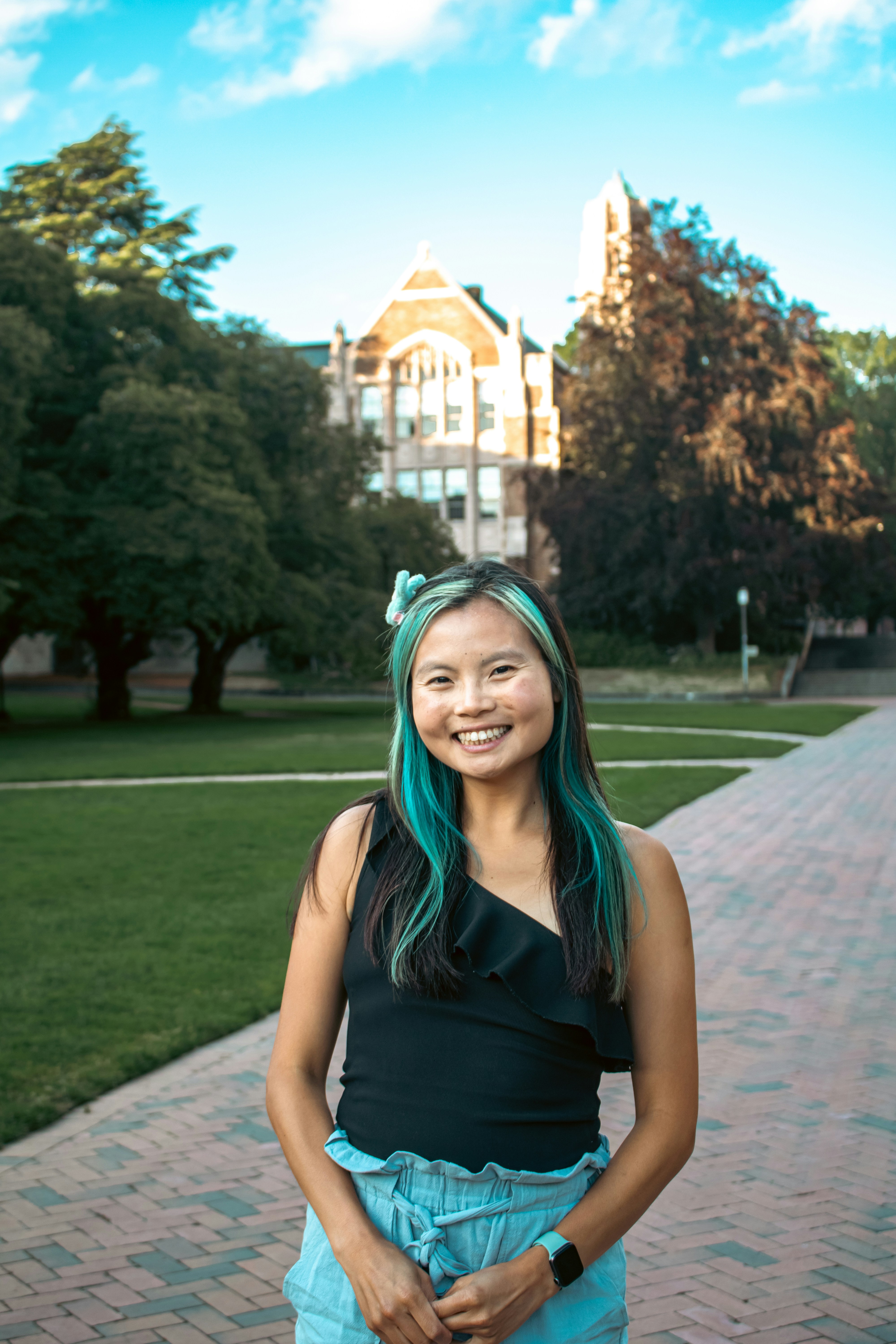 A woman with green hair standing in front of a building