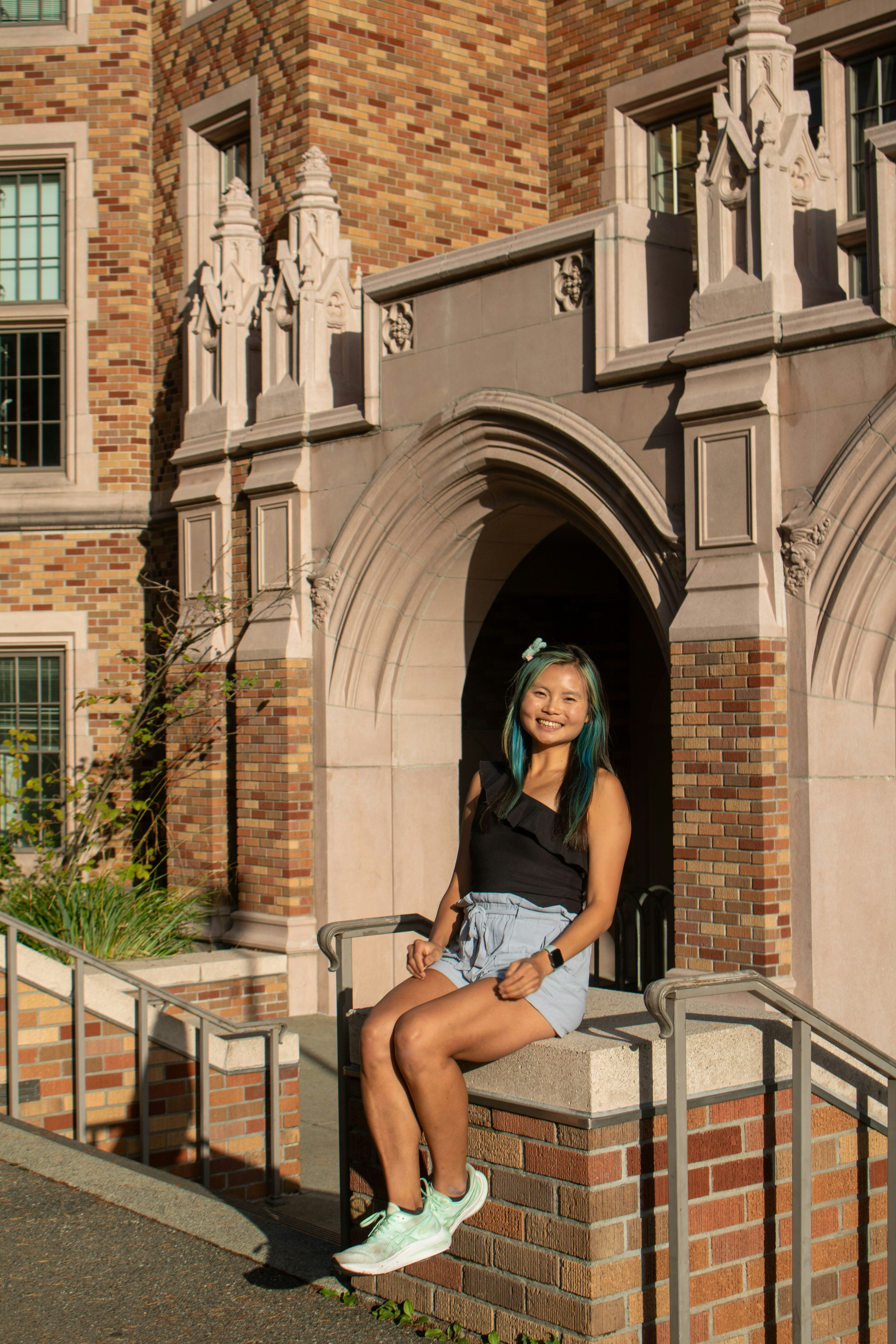 A woman sitting on a ledge in front of a building