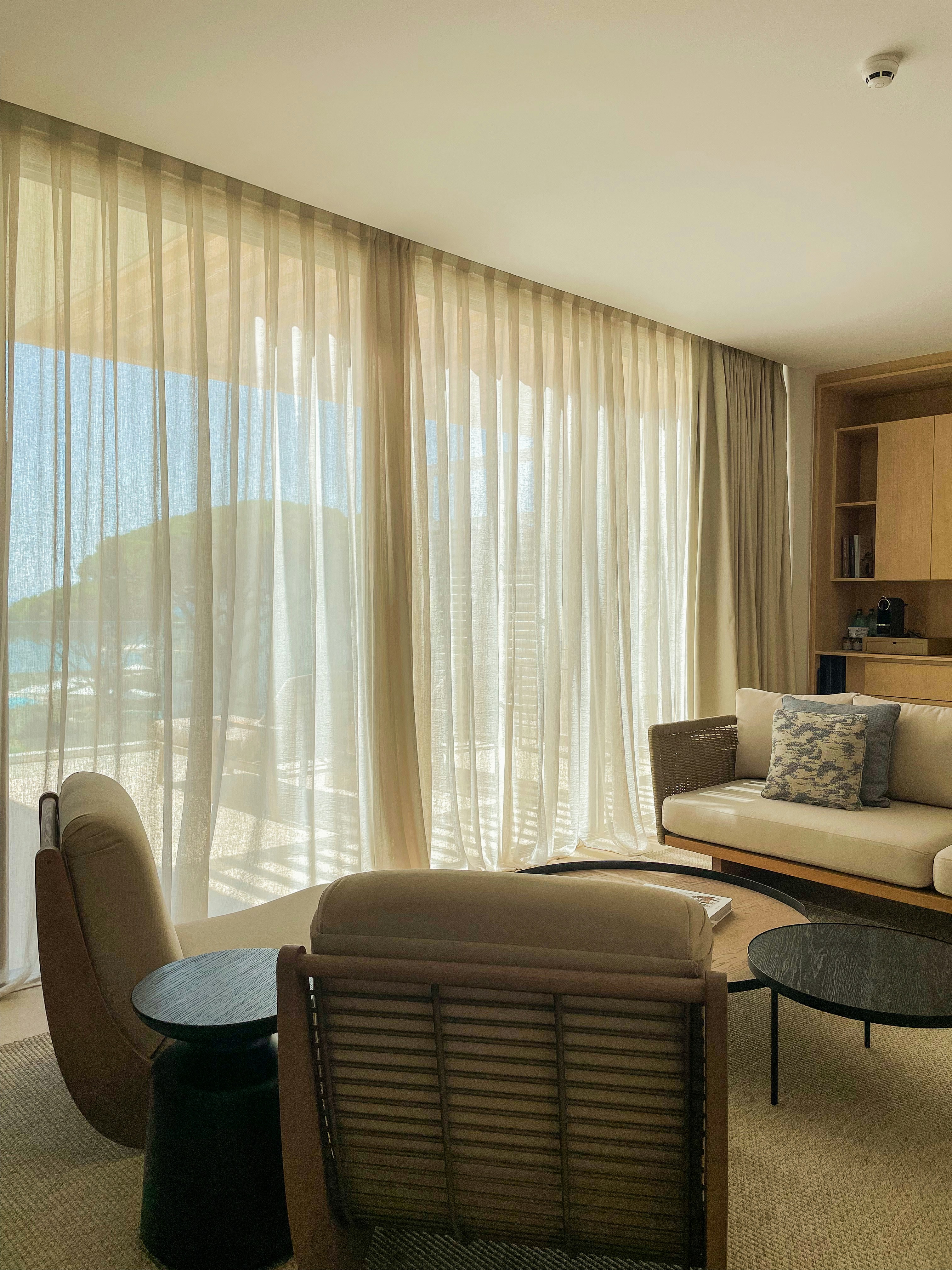 Bright living room with natural linen sheer curtains, sunlight filtering through, airy minimal interior