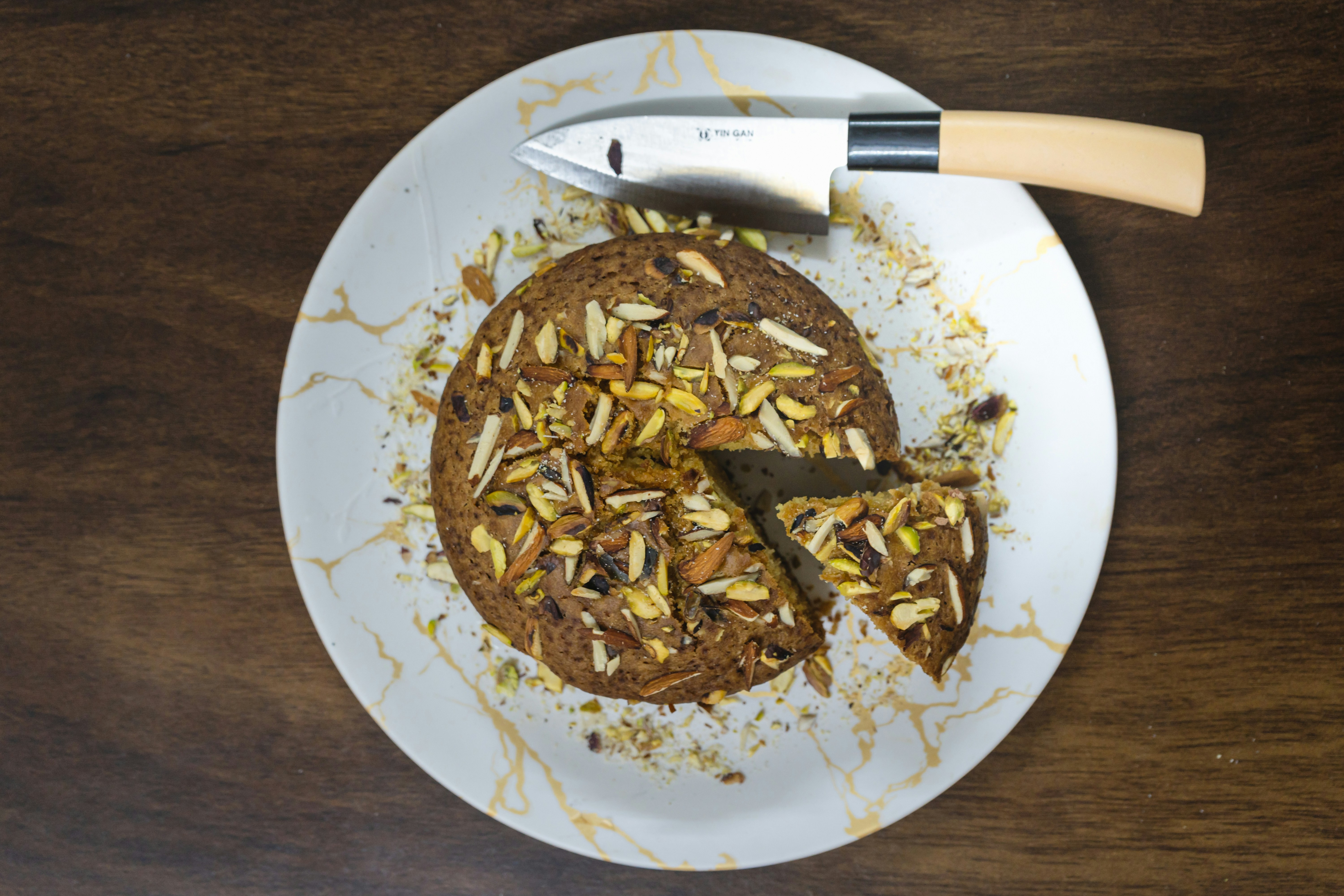 A white plate topped with a cookie and a knife