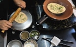 A person cooking food on top of a stove