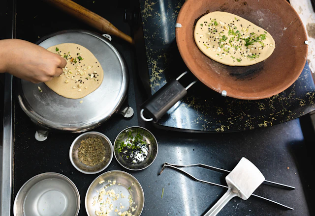 Maharashtrian thalipeeth roasting on a tawa beside spice bowls