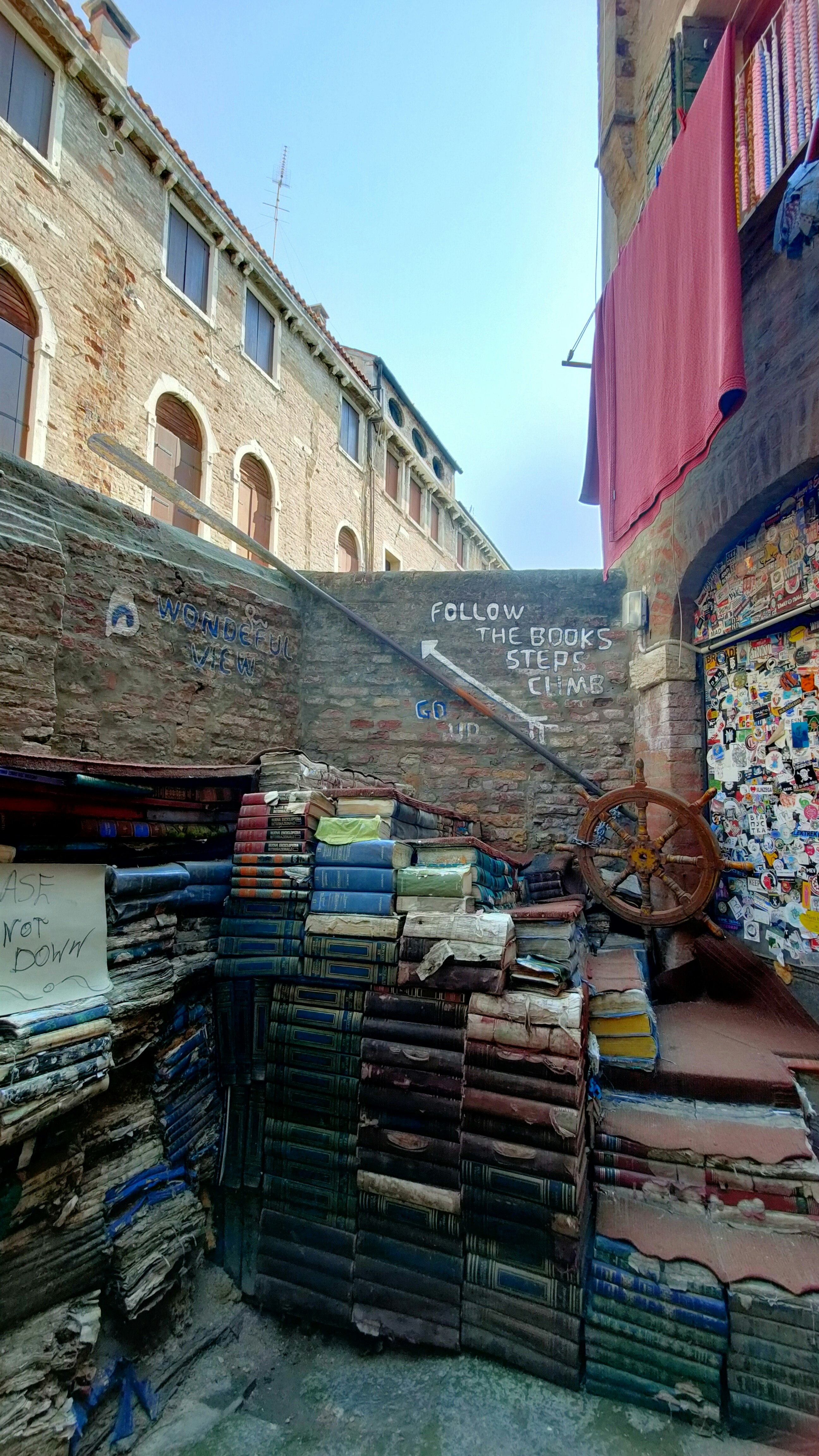 A pile of books sitting on top of a street next to a building