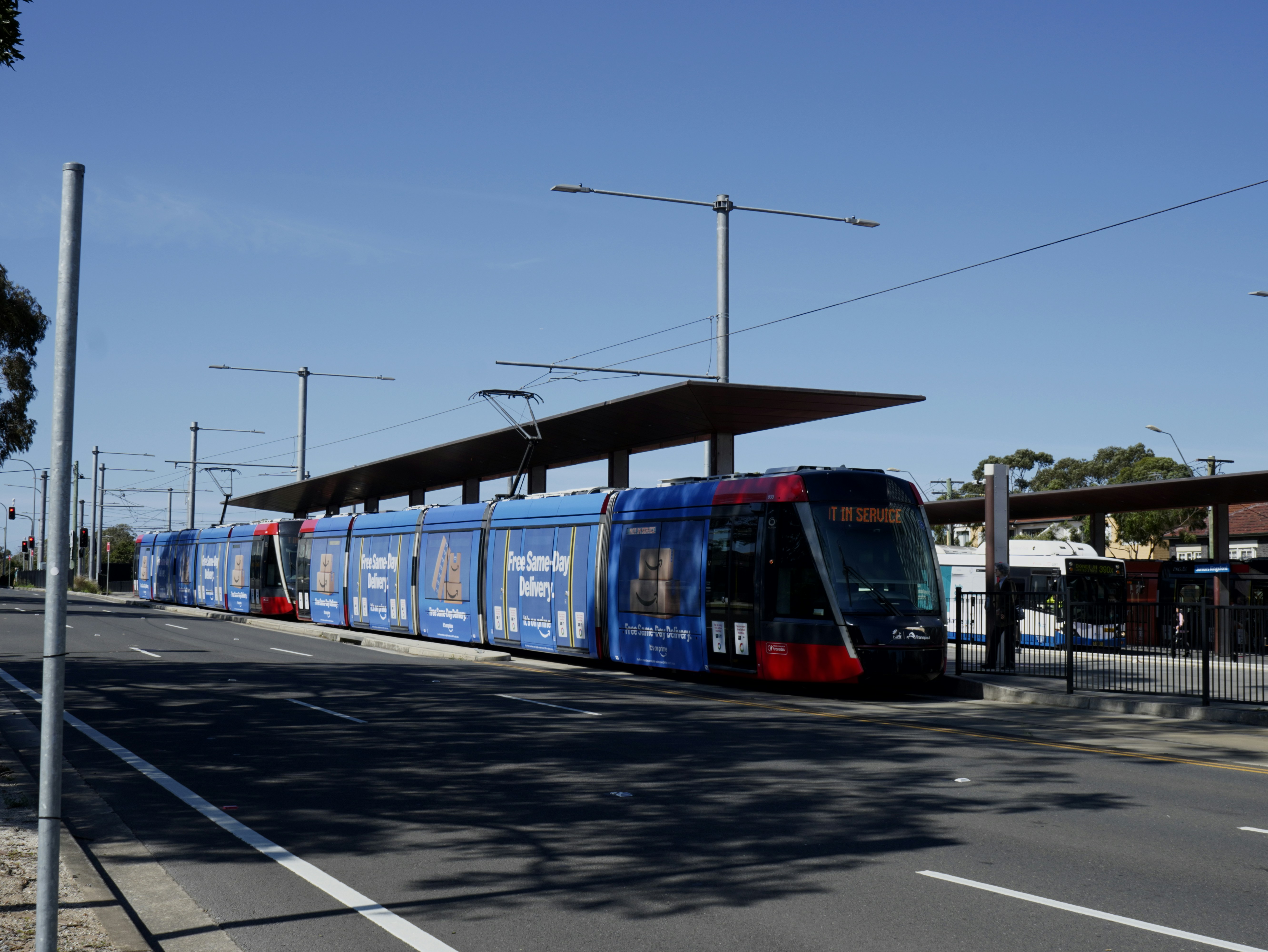 A blue and red train traveling past a train station