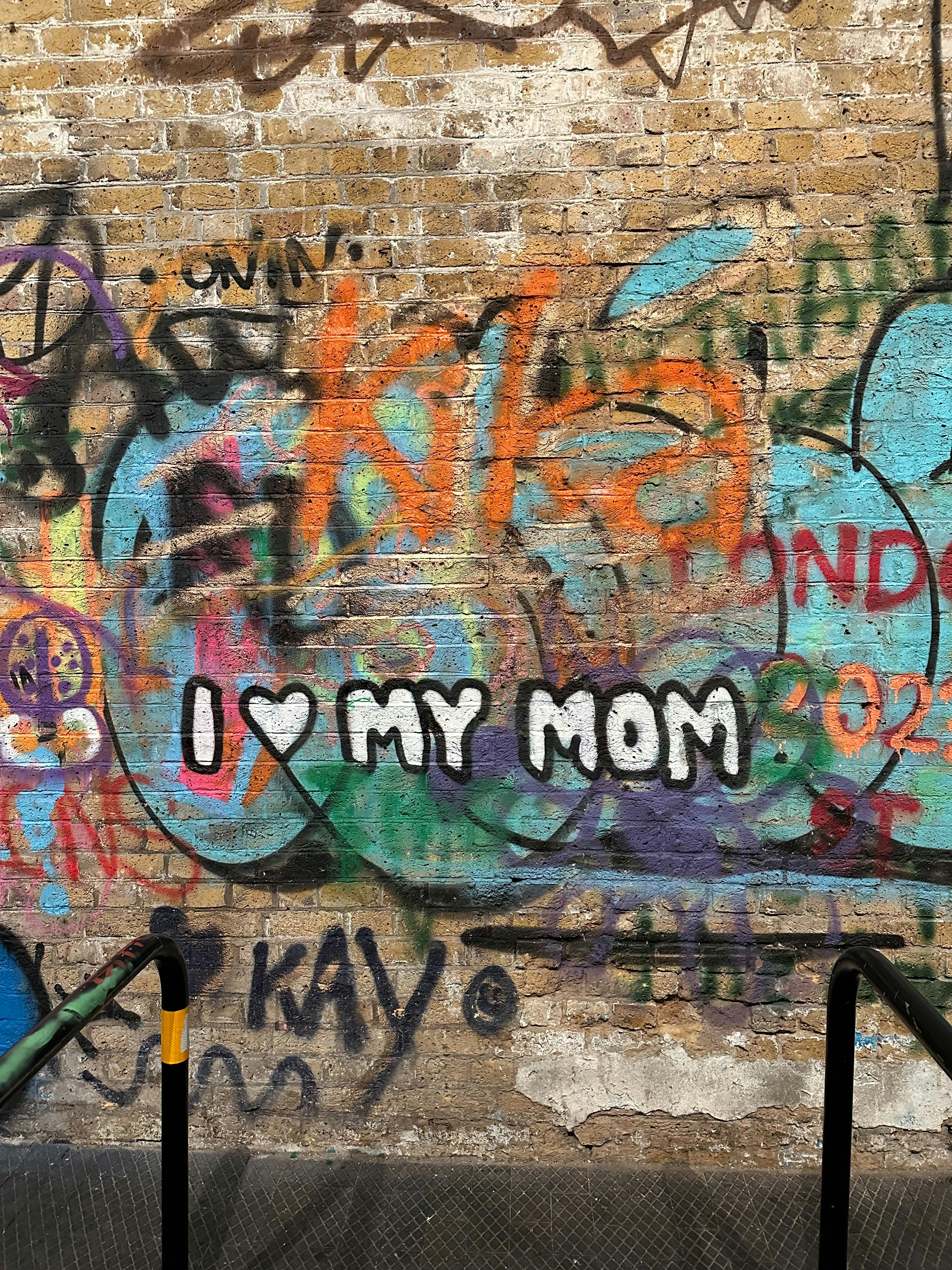 A brick wall covered in graffiti and writing