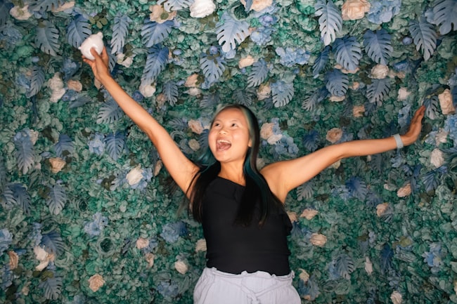 A woman standing in front of a green wall