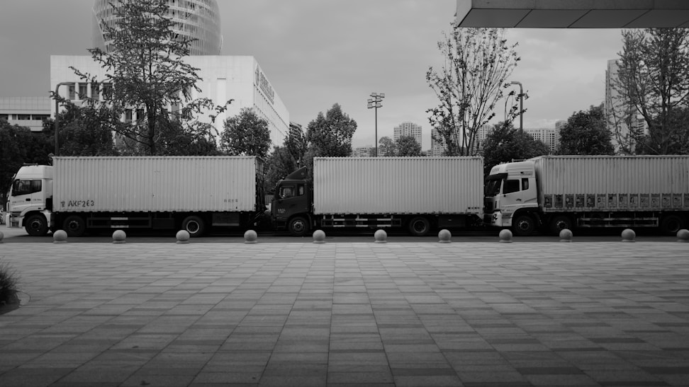 A black and white photo of trucks parked in a parking lot