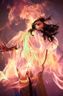 A woman in a white shirt is dancing with fire
