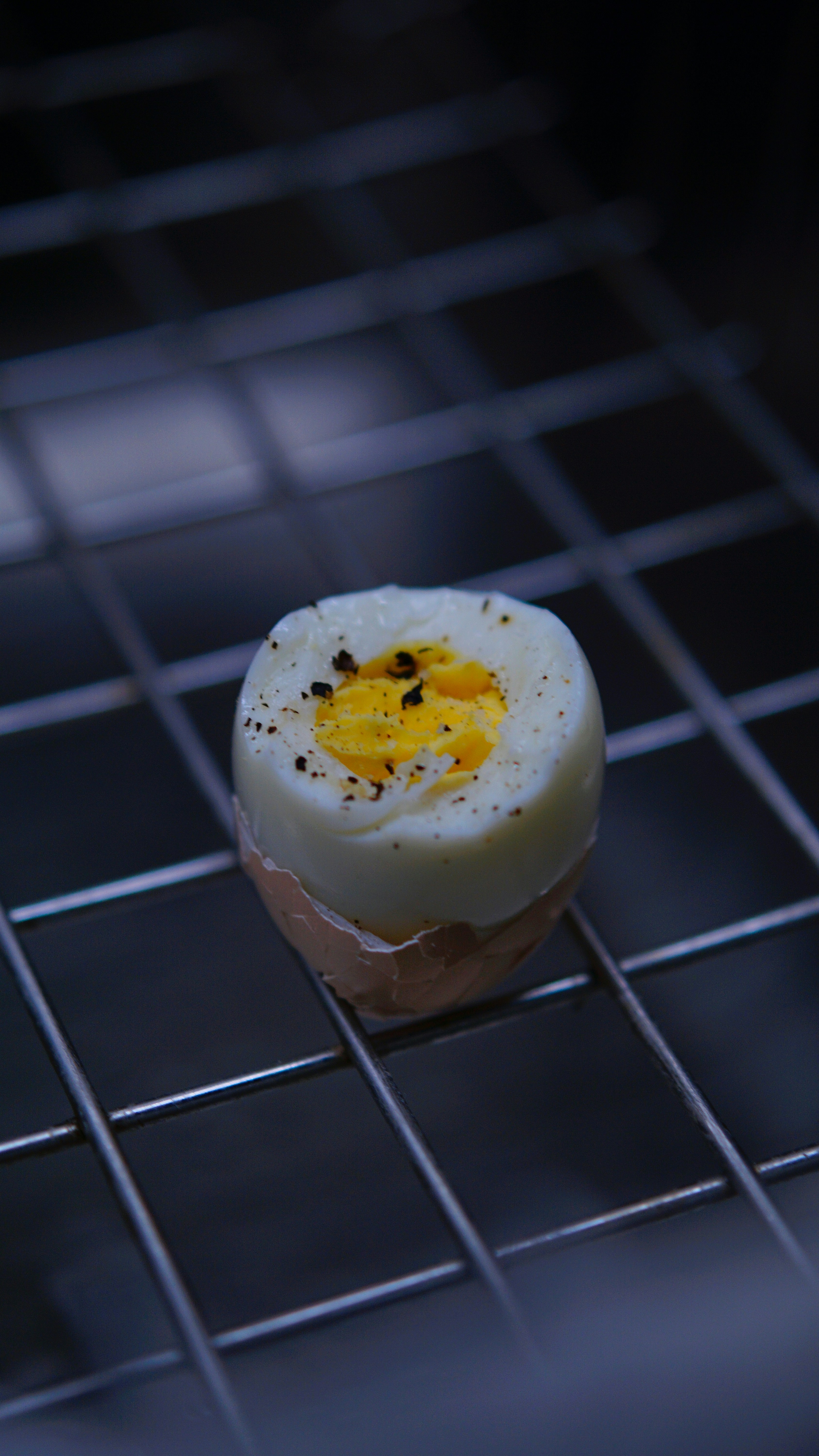 A hard boiled egg sitting on top of a wire rack