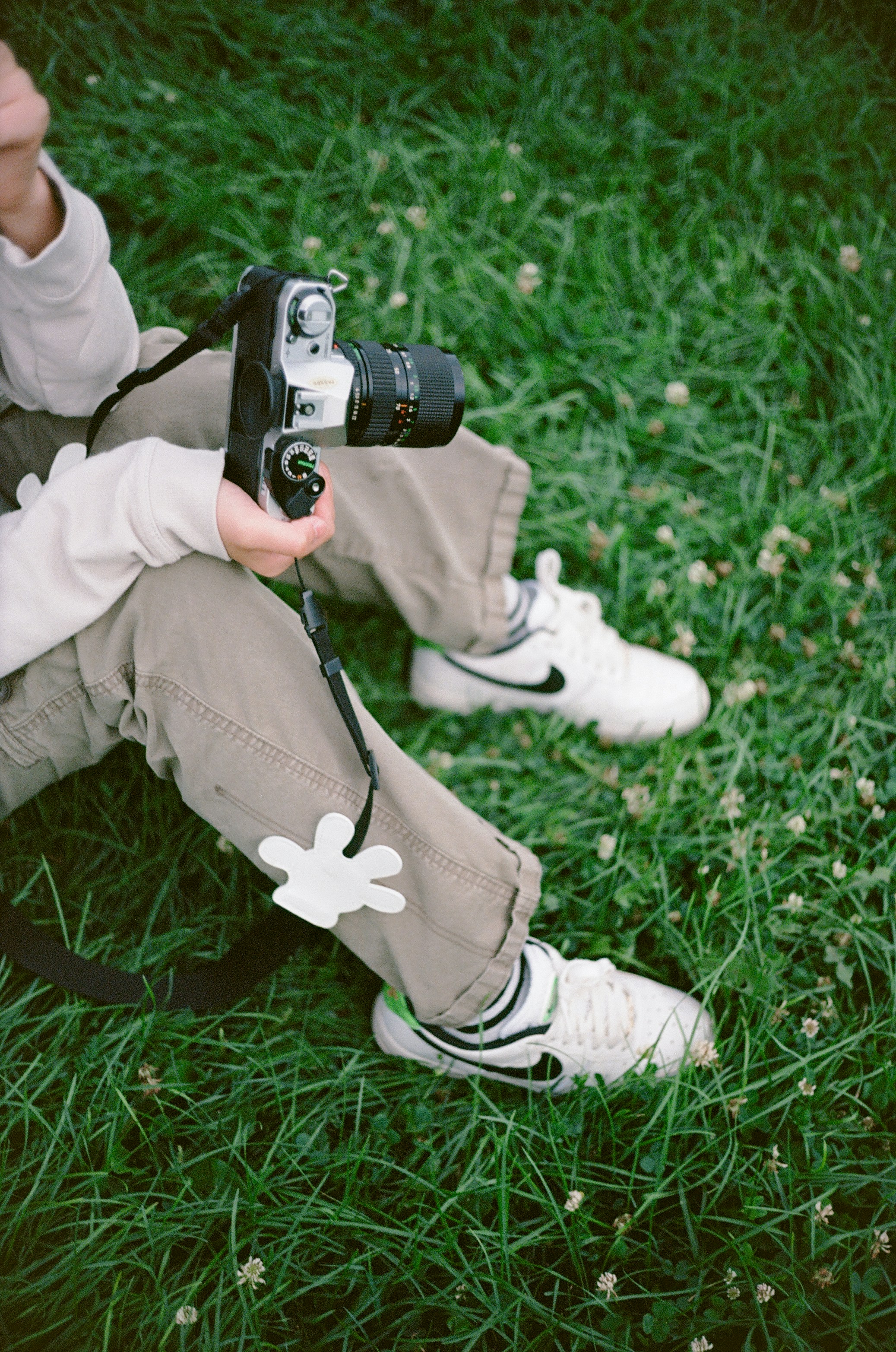 A person sitting in the grass with a camera