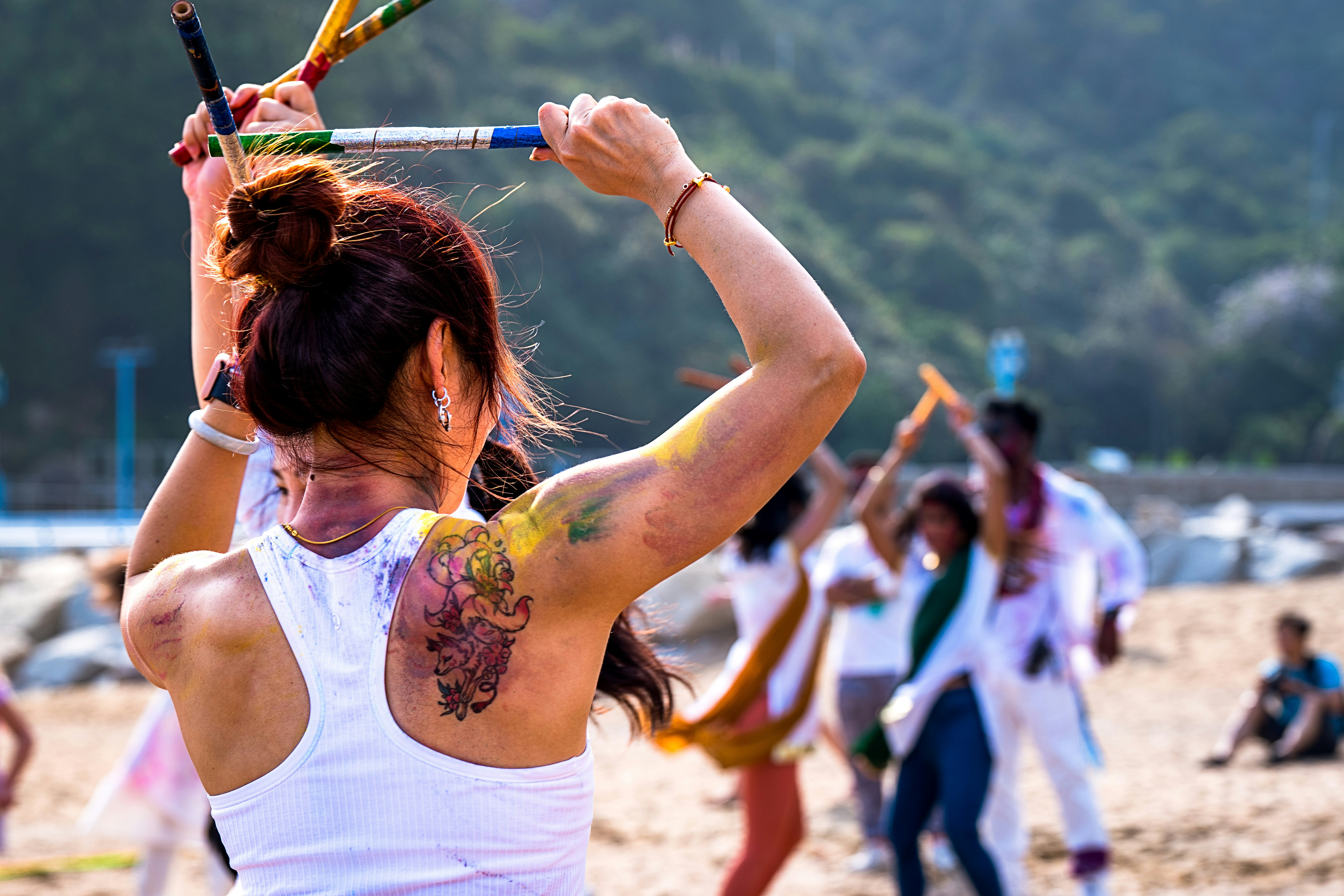 A woman holding a tennis racquet on top of a sandy beach