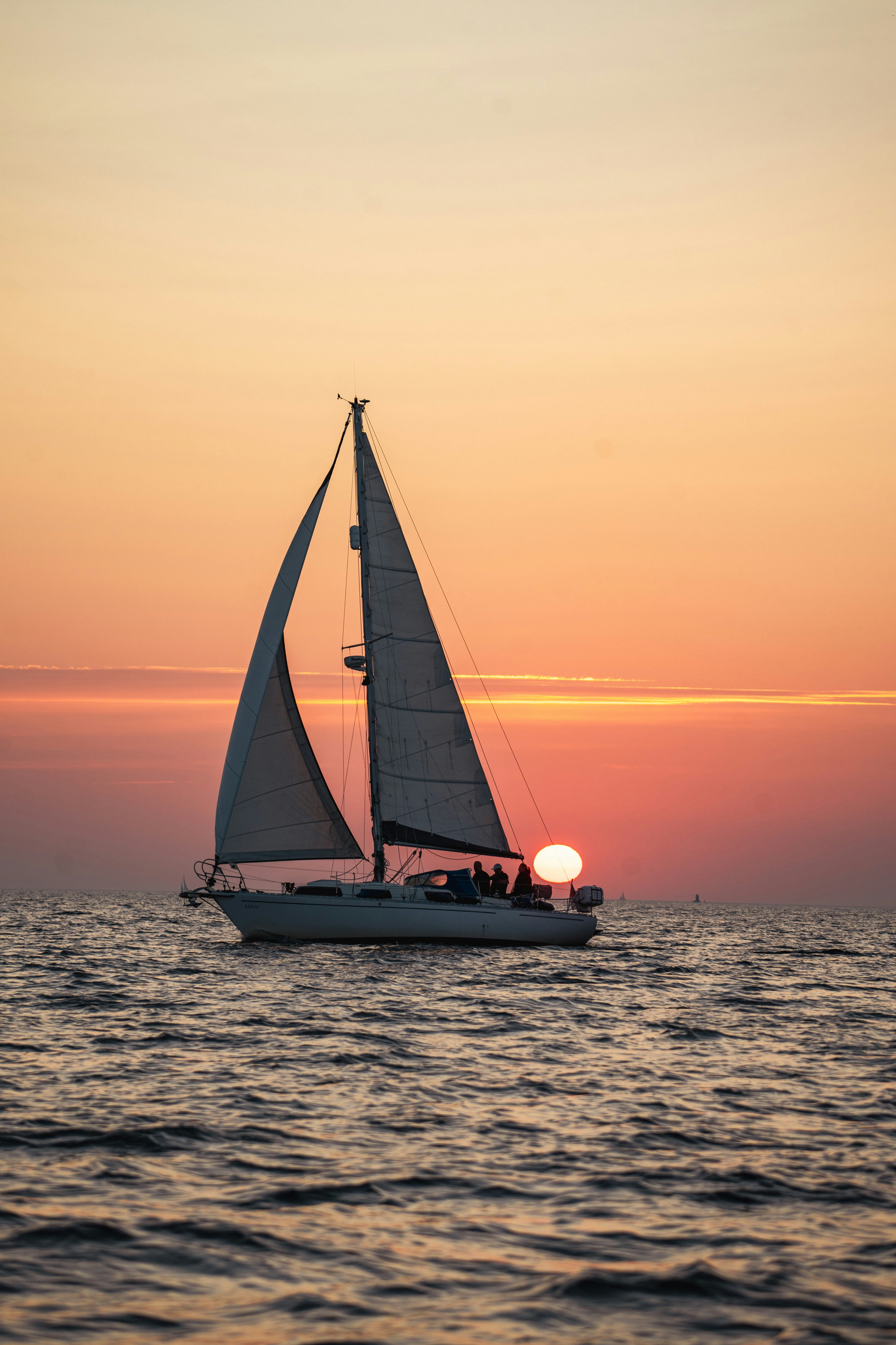 A sailboat in the ocean at sunset