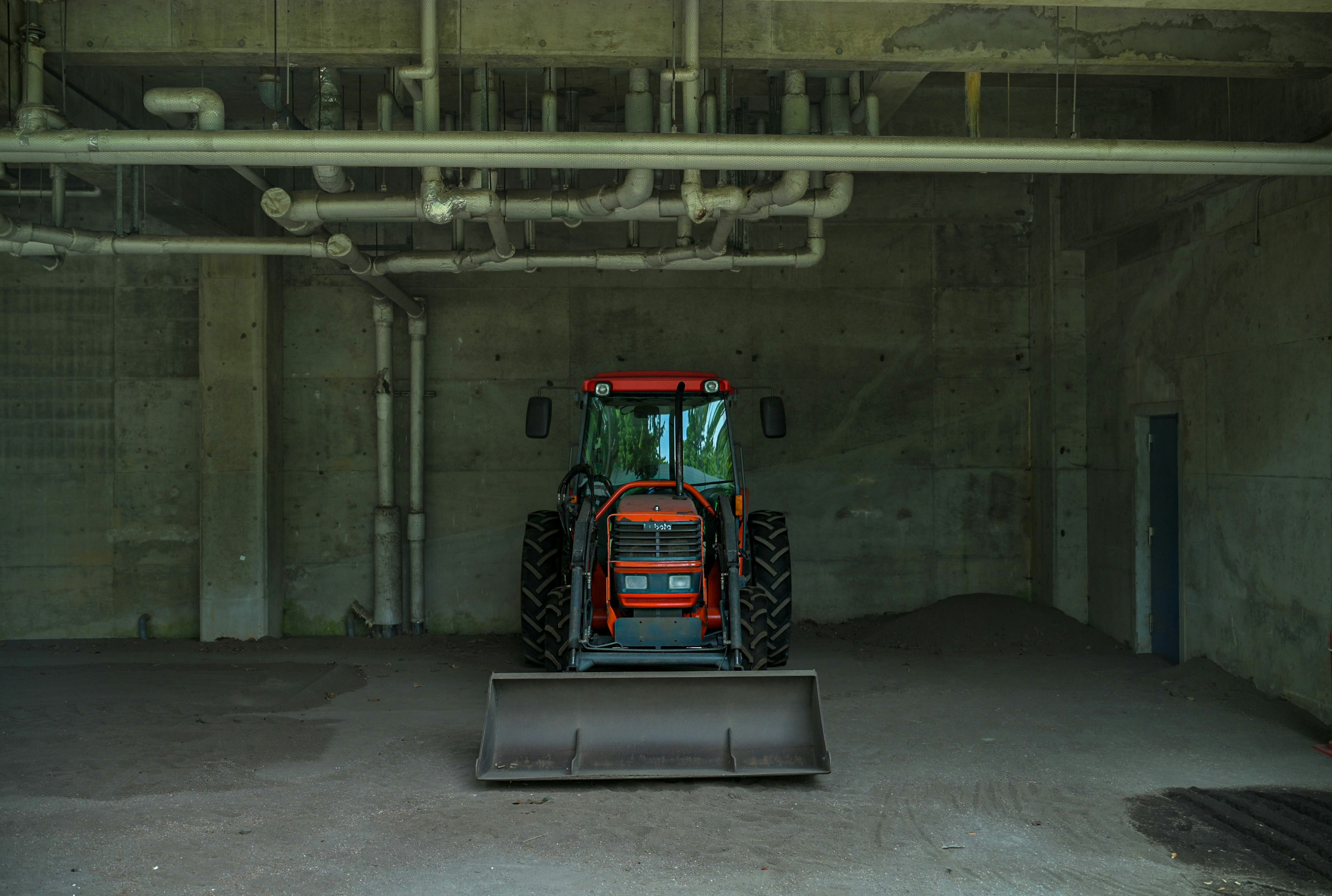 A red tractor is parked in a garage
