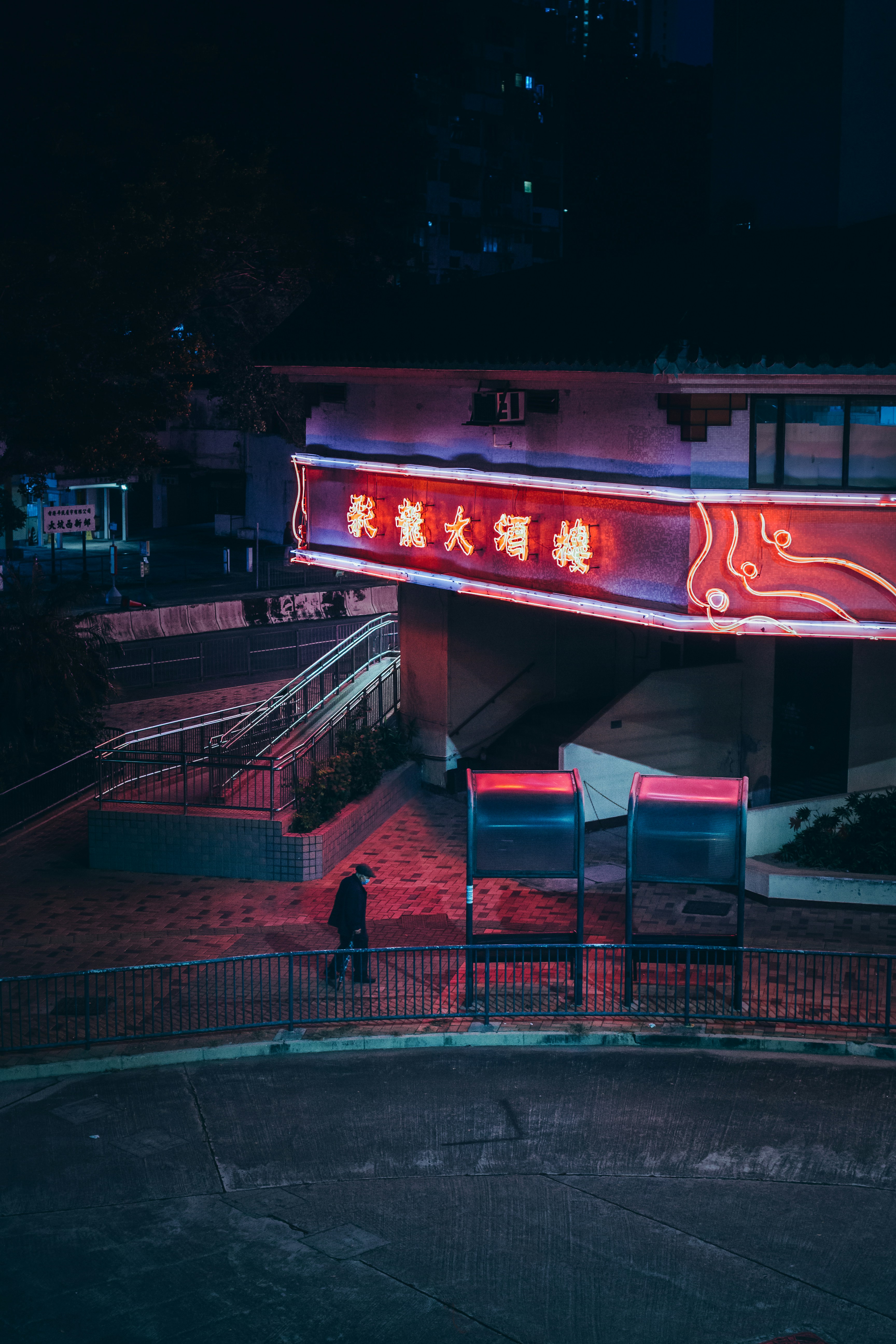 A red neon sign that is on the side of a building