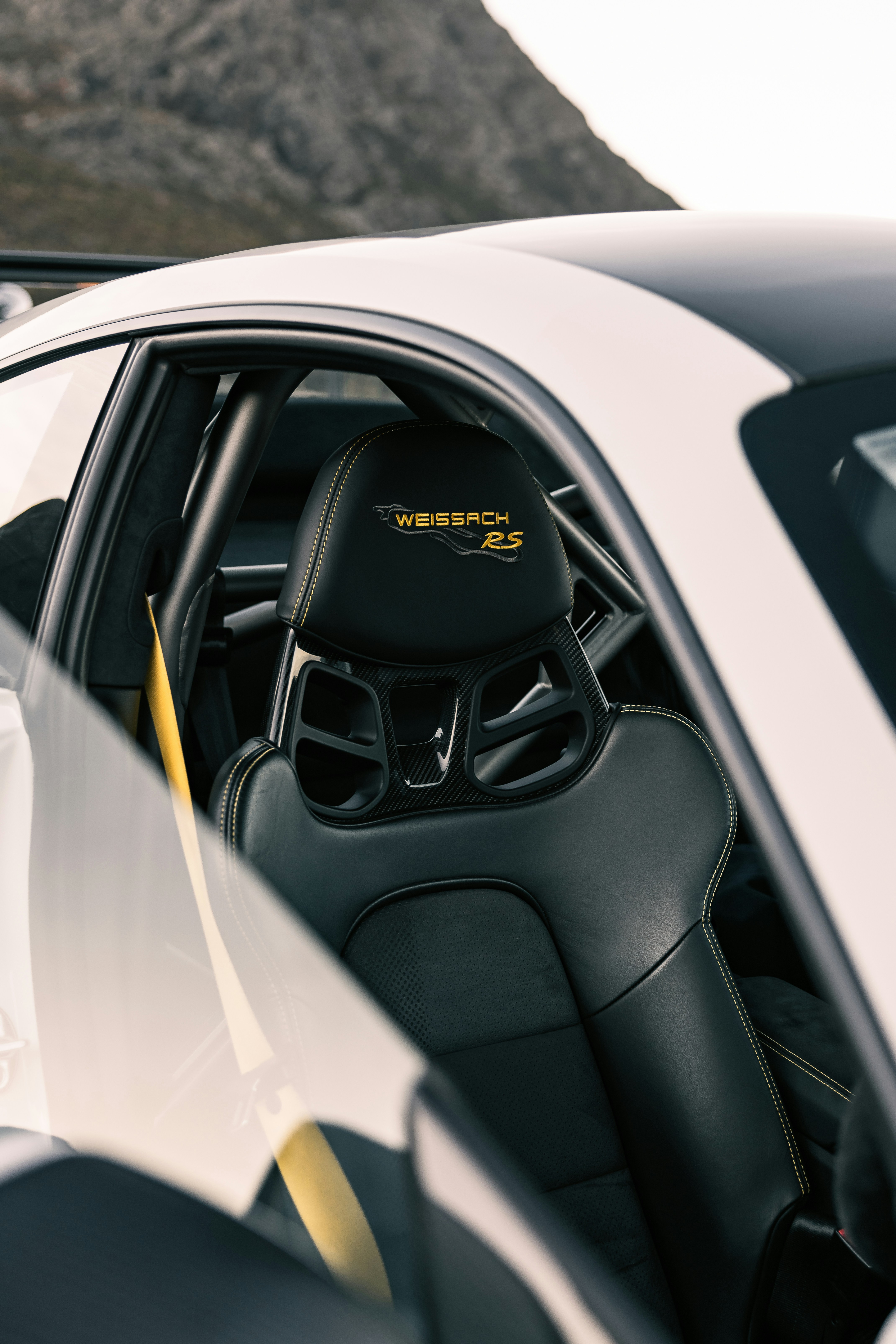 The interior of a sports car with mountains in the background