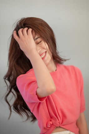 A woman in a pink shirt is smiling