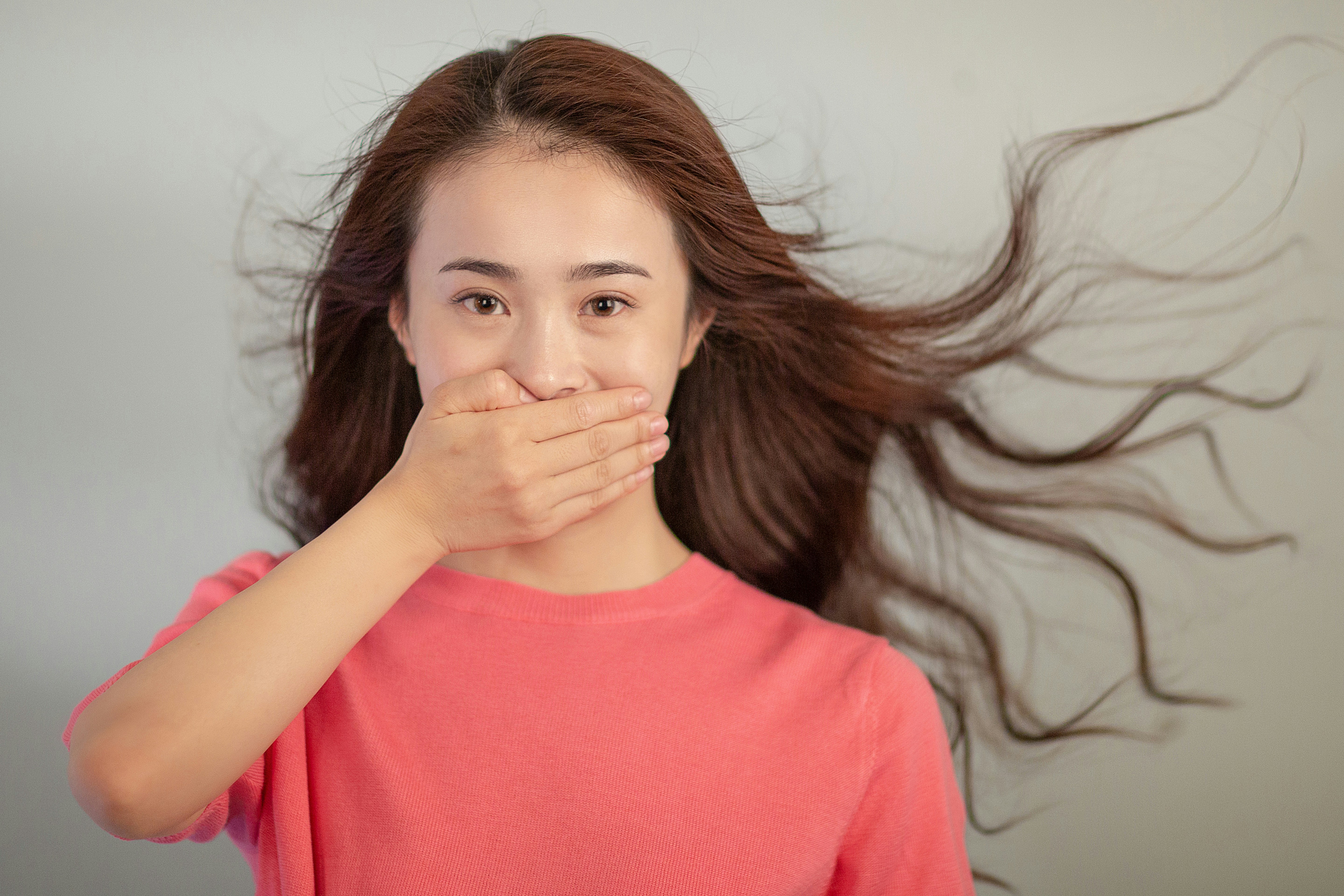 A woman covering her mouth with her hands