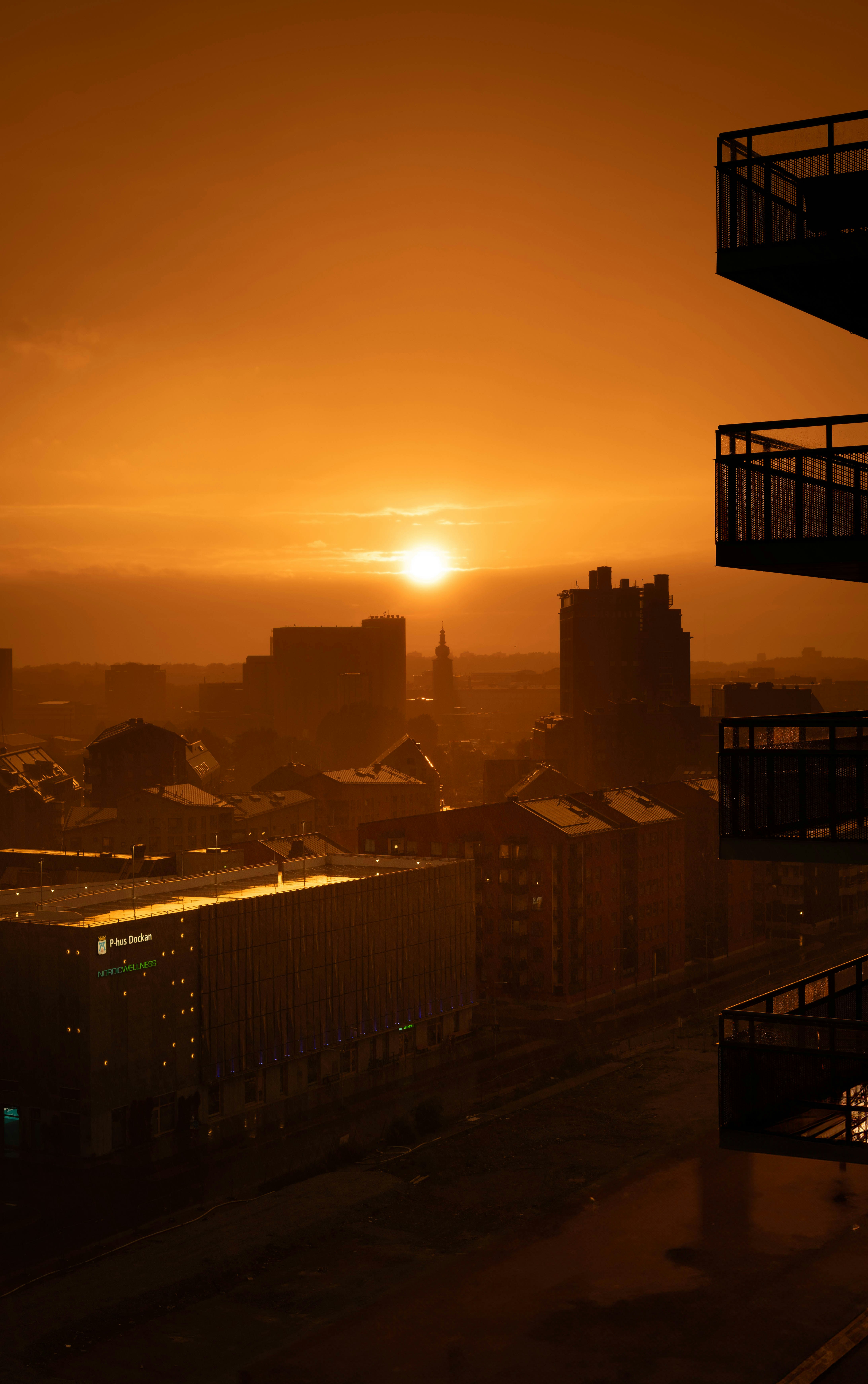 The sun is setting over a city with tall buildings